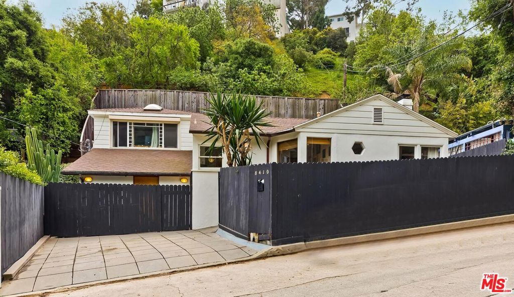 Once a working Recording Studio where legendary artists laid down tracks, this 1947 hideaway still hums with the creative spirit that defined an era. Step into a piece of music history in the heart of Laurel Canyon. Tucked behind gates in the iconic "Kirkwood Bowl," the 3-bedroom, 1.5-bath home offers an inspiring setting for musicians, writers, and artists alike. Original hardwood floors, a classic fireplace, and vintage details set the stage inside, where a warm, character-rich layout invites you to relax and create. The upstairs primary bedroom opens to a private deck with peaceful canyon views, while a third bedroom downstairs adds flexibility, perfect for a guest room, music studio, or office. Outside, a lush, tiered backyard offers a secluded, fully fenced space for entertaining or quiet reflection. All within the desirable Wonderland Avenue Elementary School district and moments from Canyon Country Store and Sunset Boulevard. A rare opportunity to live in an authentic slice of Laurel Canyon's musical and artistic legacy.