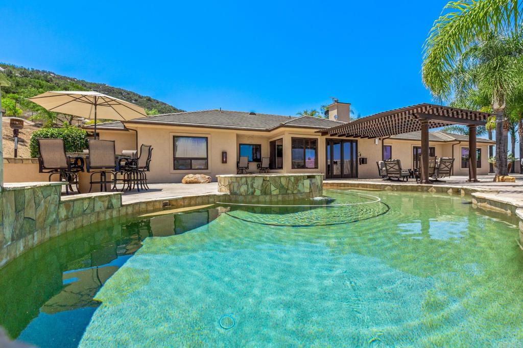 Welcome to your private, gated estate in North Escondido—an exceptional income-producing property on 5.69 acres with no HOA fees! The expansive 3,700 sq ft main ranch-style home offers 4 bedrooms, 5 baths, and modern comforts throughout, including individually controlled room thermostats, paid-off solar, tankless water heaters, a water softener, and whole-property WiFi coverage. Beyond the main residence are four detached ADUs, thoughtfully separated for privacy and currently generating over $7,000/month in rental income—an incredible opportunity for multigenerational living or investment. Outdoor amenities include a sparkling pool, basketball and tennis courts, decomposed granite landscaping, and space for horses. Sold fully furnished, this turnkey retreat is just minutes from Welk Resort and local conveniences—yet feels worlds away. Don’t miss this rare combination of luxury, privacy, and passive income!