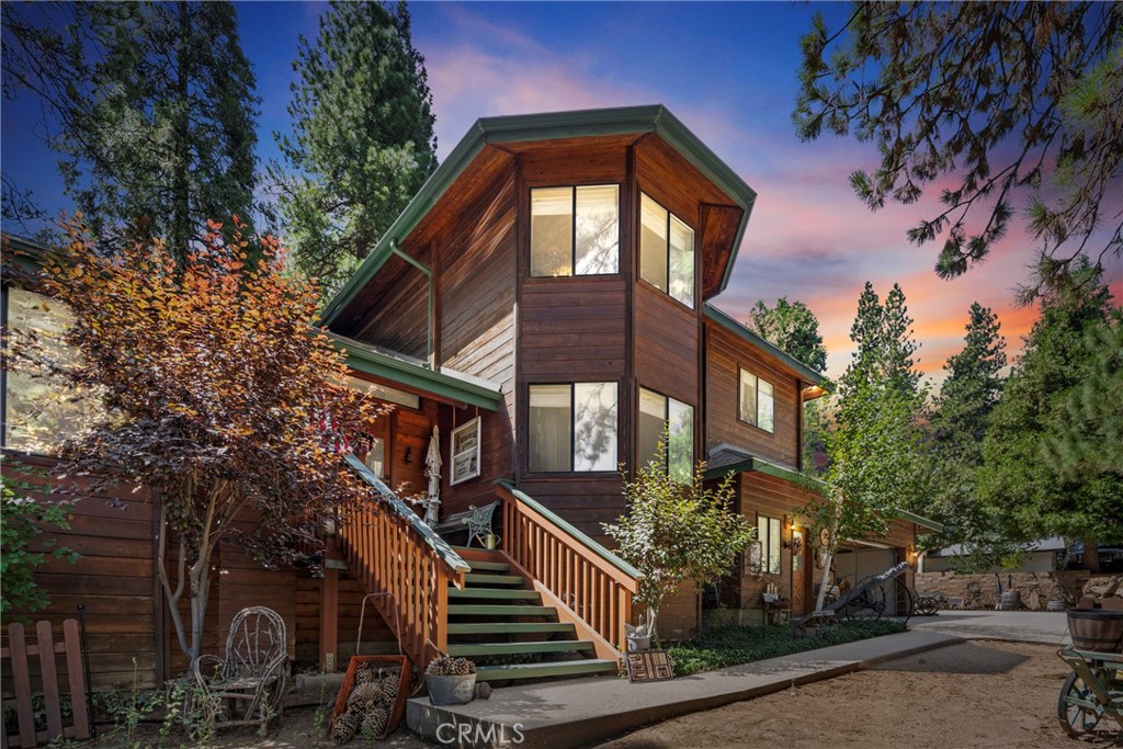 Magnificent Rustic 4+ Bedrooms with 3 Baths on a FLAT over 18,000 sq ft lot. Oversized two car garage with separate workshop space. Concrete driveway with parking for 10+ cars or an RV and Boat and still room for several cars. Backs up to the over 200 acres of the Thousand Pines Camp. Grand entrance Hall into this mansion like home that has quality wood paneling inside and out. Vaulted open beamed ceilings. Unique design touches throughout the house. Huge Living Room/Dining area on the left w/wood burning fireplace. Just down the hall, a recently remodeled large kitchen with a restored antique stove, double door side by side refrigerator and center island. Kitchen is open to large Family Room with wood burning stove and an exit out to a large concrete patio and a forest of trees. Den on main floor converted into an additional Bedroom making 5 with adjoining custom designed Bath. Separate laundry room. Upstairs is a small sitting area and double doors opening into a huge Master Bedroom and Bath with spa tub. 2 closets w/one a walk in. 3 more Bedrooms and a Bath down the hall. Ceiling Fans in nearly every room. Dual pane windows. Newer upper/lower zoned forced air heating system. Roof 10 years old. Newer water heater. Separate storage and wood sheds. Located in the exclusive Mile High Park area of Crestline.