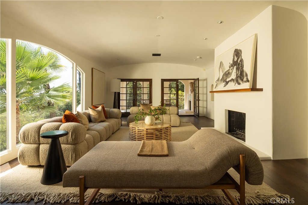 Nestled amid the leafy tranquility of prestigious Los Feliz is this 1923 Mediterranean-inspired estate—once home to Forrest J. Ackerman—legendary collector, writer, and inspiration to Hollywood’s greats. This piece of history, known as ‘The Ackermansion,’ was recently re-imagined to showcase masterful craftsmanship, bespoke detailing and integrated art installations by a world-renowned artist.
Enter through a grand foyer into an expansive living room, where floor-to-ceiling windows frame sweeping views of the Los Angeles skyline. Through double French doors, a cabana-style lounge with its own fireplace provides a cozy retreat. The interior includes a ground-level remodel in collaboration with Hub of the House Studio, featuring custom Hart & Toth cabinetry. A romantic Juliette window in the dining room overlooks your own private forest, while the chef’s kitchen features artisan concrete counters, designer appliances, and hand-troweled clay and plasterwork.
Within this walled and privately-gated compound, 4 fireplaces, 6 patios, and a sparkling pool offer endless possibilities for entertaining. Soaring palms, mature birds of paradise, and cascades of bougainvillea will have you feeling like you’re worlds away. Designed for seamless indoor–outdoor living, this residence is a private sanctuary just minutes from Griffith Park hiking trails, the Observatory, and the heartbeat of Los Angeles.
