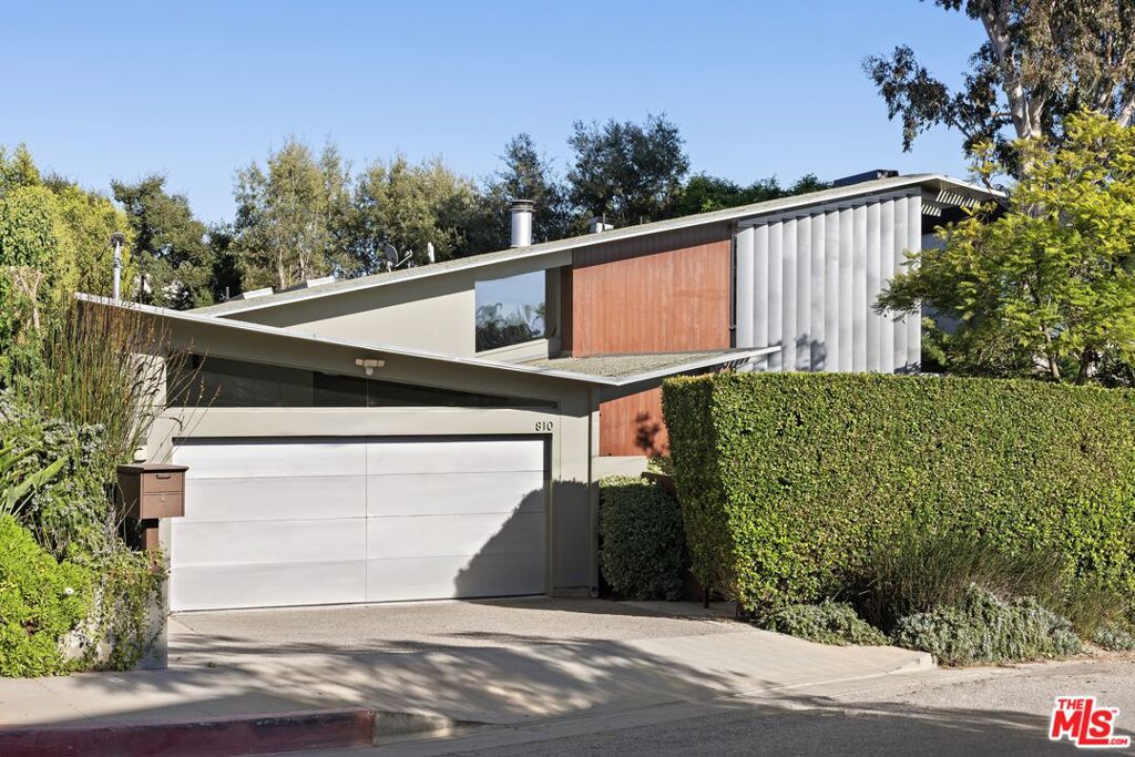 Welcome to 810 N Tigertail, a unique property that flawlessly unites classic mid-century post-and-beam architecture with the sleek sophistication of modernist design ideals. Nestled on a sprawling oak-filled lot, this meticulously reimagined 1950s home offers breathtaking canyon and Getty views that set the stage for a spectacular open plan haven that seamlessly blends indoor and outdoor living. Designed by acclaimed architect Cory Buckner, the residence features dynamic rooflines, clerestory windows and floor-to-ceiling glass that invites natural light to flood the space and make every room feel like a retreat into nature. The heart of the home lies in the expansive main living area, which flows effortlessly into the vibrant, chic kitchen, perfect for everything from casual corner booth meals to gourmet entertaining. This space extends seamlessly to a spacious patio and a sprawling, grassy yard featuring multiple levels, seating areas, an outdoor kitchen and a mini basketball court all beautifully enclosed by nature. The impressive primary bedroom wing is a sanctuary unto itself, offering expansive space, soaring ceilings, a private patio, a large walk-in closet and a luxurious bathroom that exudes elegance and tranquility. In essence, 810 N Tigertail embodies the pinnacle of California living where every element from the architecture to the landscaping was designed to offer a perfect balance of luxury, serenity and memories to last a lifetime. Upstairs secondary living room lends itself to a second primary bedroom if desired.