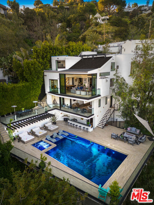 Available for lease starting August, showings available beforehand. This property comes fully furnished and is all set for you to move in right away. It is available for both short-term and long-term rentals. Located right next to the Sunset Strip, this modern three-story estate boasts four luxurious bedrooms and five beautifully appointed en-suite bathrooms. Ideal for hosting and entertaining, this property offers a full gourmet kitchen, billiards table, private theater and gym, and hardwood throughout. Outside you can find breathtaking city views from the backyard dining terrace, pool & spa, plus an incredible single car garage and driveway with ample street parking.