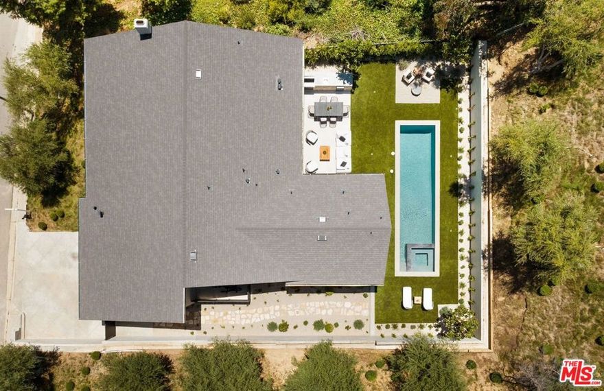 Just Reduced $400K! Nestled in the prestigious Laurel Hills neighborhood of the Hollywood Hills, this modern-style home channels a refined Soho Treehouse aesthetic with canyon views and timeless design. The open-concept layout blends spacious living areas with vaulted ceilings, creating an ideal flow for both entertaining and everyday living. Featuring three serene bedrooms and three luxurious bathrooms, the home showcases natural stone finishes, Portola lime wash walls, and custom built-ins throughout. European white oak floors, large picture windows, and thoughtfully curated high-end finishes add warmth, light, and sophistication to every room. The smooth stucco exterior with sleek brass gutters contrasts beautifully with the home's neutral palette and modern architectural lines. Surrounded by lush landscaping and mature olive trees, the grounds include expansive decks, a grassy yard, a sparkling pool, and panoramic city views. Additional features include Control 4 Home automation, Lutron lighting, a tankless water heater, new plumbing and electrical, two-car garage with EV charging, and driveway parking for two more vehicles. This private oasis perfectly balances modern luxury and European-inspired charman exceptional retreat not to be missed.