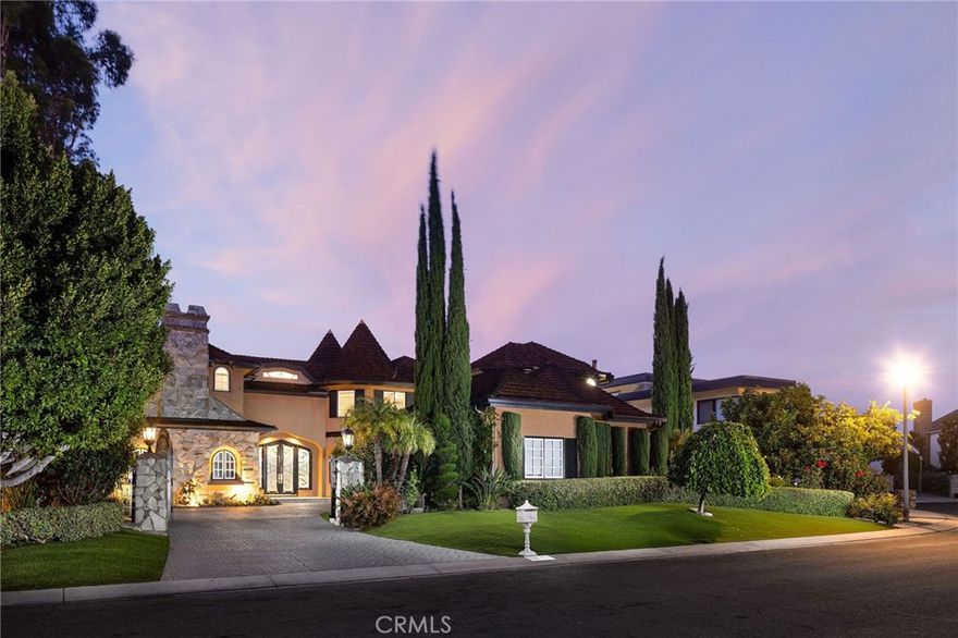 This exceptional, custom Nellie Gail Ranch view home offers true resort-style living with sweeping mountain, canyon and city light views from nearly half an acre of private, equestrian-zoned grounds. Upon arrival, stately entry gates open to a brick motorcourt and generous three-car garage. Ornate, oversized double entry doors reveal an interior of dramatic scale and proportion, spanning over 5,800 square feet. The foyer features floor-to-ceiling windows, filling the space with natural light, and a sweeping wrought-iron staircase leads to private quarters above. The grand formal dining room is ready for gatherings, while the living room features a contemporary fireplace and marble wet bar with wine storage, all complemented by priceless views. A second dining area flows seamlessly into the gourmet chef's kitchen, equipped with Viking appliances, abundant quartz counters, upgraded cabinetry and walk-in pantry. The large center quartz island with cooktop and breakfast bar seating invites casual meals and conversation. Neighboring the kitchen, you will find the well-equipped laundry room with upgraded LG front-loaders, additional sink and storage, and direct exterior door. The main level also includes a versatile office or home theatre/bonus room with blackout shades, fireplace, extensive built-ins and adjacent ½ bath. The primary suite serves as a private retreat with its own sitting room, fireplace, and stunning views. Outside, a terraced patio hardscape with multiple sundecks surrounds the inviting pool and spa, all overlooking endless views and shrouded in mature landscaping for ultimate privacy. Expansive Trex decking features a covered, fully equipped outdoor kitchen and bar, an entertainer’s dream. The lower deck area includes a gazebo lounge and TV area. Additional upgrades include full Pex repipe, Eagle-light roofing system and upgraded windows and doors. Nellie Gail Ranch offers exceptional value with low HOA fees covering security, trail maintenance, access to the swim, tennis and pickleball club and exclusive community events. With easy access to freeways, top schooling, shopping, dining, and world-class beaches, this special property provides the perfect blend of amenities, privacy and location. Truly a must see! Shown by private appointment only.