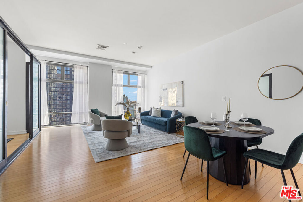 Sky Lofts is at the epicenter of DTLA in the South Park District. Perched high above the city on the 15th floor at 801 S Grand Ave, this 2-bedroom, 2-bathroom, 1,220 square foot loft-style condo offers a seamless blend of modern finishes, open-concept living, and exciting skyline views. This south facing unit has massive windows, letting natural light spill in to create an ideal backdrop for both day-to-day living and evening entertaining. 10 foot high ceilings add to the loft style vibes. The kitchen is open to the living room with a breakfast bar/island with plenty of storage and seating capability as well as a dining area between the kitchen and living room. Off of the living room there is primary bedroom suite with a spacious ensuite bathroom that includes a double vanity, a large tub and separate shower. Attached to the primary bathroom is a large closet. The 2nd bedroom, off the main entryway, is perfect as an office or guest bedroom and situated next to the 2nd full bathroom. There are light hardwood floors throughout the unit giving it a modern and bright tone. In addition, there is an in unit washer and dryer closet and central heat and air conditioning. The list of building amenities are impressive - a premium updated gym, a movie/media room with comfy theatre style seating, a clubhouse/entertainment room with a full kitchen that can be booked for events and a 24 hour security desk in the lobby. The unit includes two side by side parking spaces in the underground garage. There is a separate garage on site with ample visitor parking for guests. Nightlife, dining, entertainment and shopping are minutes away. Notable restaurants nearby like Bottega Louie, Water Grill, 71 Above and LeGrand. Across the street from Whole Foods and within 5 blocks from Crypto.com arena. If you're looking for a downtown city lifestyle with a walkable neighborhood and vibrant culture, then 801 Grand Ave is the place to be.