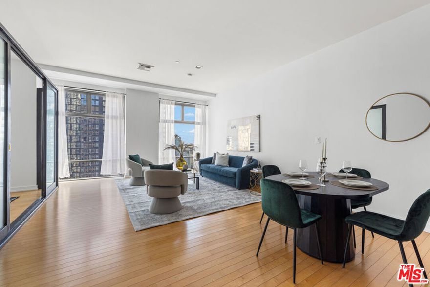 Sky Lofts is at the epicenter of DTLA in the South Park District. Perched high above the city on the 15th floor at 801 S Grand Ave, this 2-bedroom, 2-bathroom, 1,220 square foot loft-style condo offers a seamless blend of modern finishes, open-concept living, and exciting skyline views. This south facing unit has massive windows, letting natural light spill in to create an ideal backdrop for both day-to-day living and evening entertaining. 10 foot high ceilings add to the loft style vibes. The kitchen is open to the living room with a breakfast bar/island with plenty of storage and seating capability as well as a dining area between the kitchen and living room. Off of the living room there is primary bedroom suite with a spacious ensuite bathroom that includes a double vanity, a large tub and separate shower. Attached to the primary bathroom is a large closet. The 2nd bedroom, off the main entryway, is perfect as an office or guest bedroom and situated next to the 2nd full bathroom. There are light hardwood floors throughout the unit giving it a modern and bright tone. In addition, there is an in unit washer and dryer closet and central heat and air conditioning. The list of building amenities are impressive - a premium updated gym, a movie/media room with comfy theatre style seating, a clubhouse/entertainment room with a full kitchen that can be booked for events and a 24 hour security desk in the lobby. The unit includes two side by side parking spaces in the underground garage. There is a separate garage on site with ample visitor parking for guests. Nightlife, dining, entertainment and shopping are minutes away. Notable restaurants nearby like Bottega Louie, Water Grill, 71 Above and LeGrand. Across the street from Whole Foods and within 5 blocks from Crypto.com arena. If you're looking for a downtown city lifestyle with a walkable neighborhood and vibrant culture, then 801 Grand Ave is the place to be.