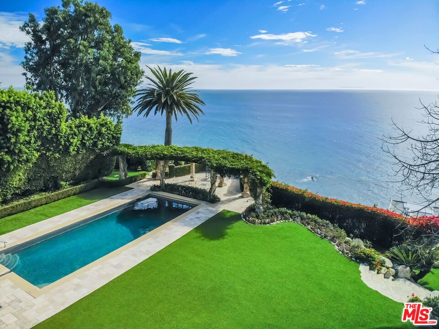Magnificent ocean view compound with a prestigious PCH address. Behind impressive gates are privacy hedges, sculptured garden, elegant two bedroom guest house, beautiful two story structure with two offices, guest suite and lighted tennis court. A long driveway leads to a dramatic main residence with high arches and barreled and coffered ceilings. The formal living room flows through windowed doors to a stone patio with fireplace, pool and spa, dining and lounging areas, barbecue, bar, expansive lawn and trellised sitting area overlooking the Pacific.  The views throughout the day are culminated by watching the setting sun.  Entertain in the stately dining room adjacent to a chef's kitchen with large island and butler's pantry that leads to a media area and dining banquette. The stunning ocean view master suite shines with his and her baths and large walk-in closets. Additional amenities include an ocean view executive office, exercise room, guest suite, custom tiled laundry room and three car garage on this magnificently manicured property. An additional parcel fronting Malibu Road known as APN: 4458-015-040 is included in the sale making the total property size approximately 1.55 acres. This spectacular coastal estate is truly one of Malibu's most coveted properties.