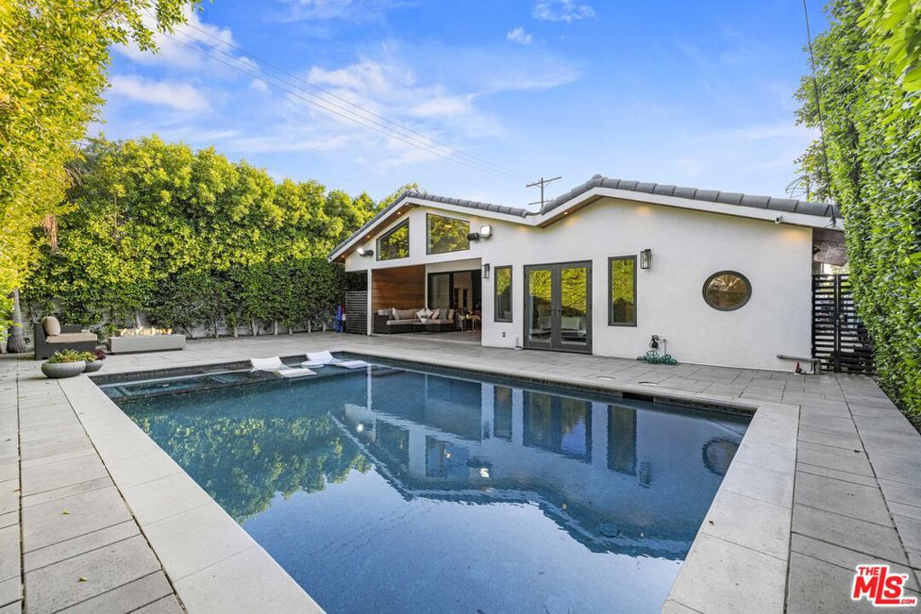 A rare offering of modern luxury, privacy, and impeccable design. This fully gated 2,436 sq ft smart home was completely remodeled in 2019, showcasing exquisite craftsmanship and premium finishes throughout. The beautifully landscaped exterior opens to a true entertainer's backyard oasis. Vaulted ceilings above the covered patio create an open-air retreat, while the Pebble Tec Baja pool and spa with built-in waterfalls invite pure relaxation. An integrated Bose surround sound system flows seamlessly from indoors to outdoors, setting the mood for every occasion. Inside, the home boasts 4 bedrooms and 3.5 designer bathrooms. You're welcomed by soaring 10+ foot ceilings, solid core caseless doors, 48x48 imported Italian porcelain tiles, and engineered hardwood floors that set the tone for elevated living. Every detail has been curated with intention, from the recessed lighting and shadow moulding to the fully custom closets and vanities. The heart of the home is the showstopping chef's kitchen featuring a massive quartz waterfall island, Italian Bertazzoni appliances, and custom cabinetry with built-in lighting, ideal for entertaining and culinary creativity. Additional highlights include a spa-inspired primary suite, sleek guest powder room, smart home features throughout, and paid-off solar panels for long-term efficiency and savings. Located in a prime neighborhood just minutes from top-rated schools, shopping, dining, and lifestyle amenities