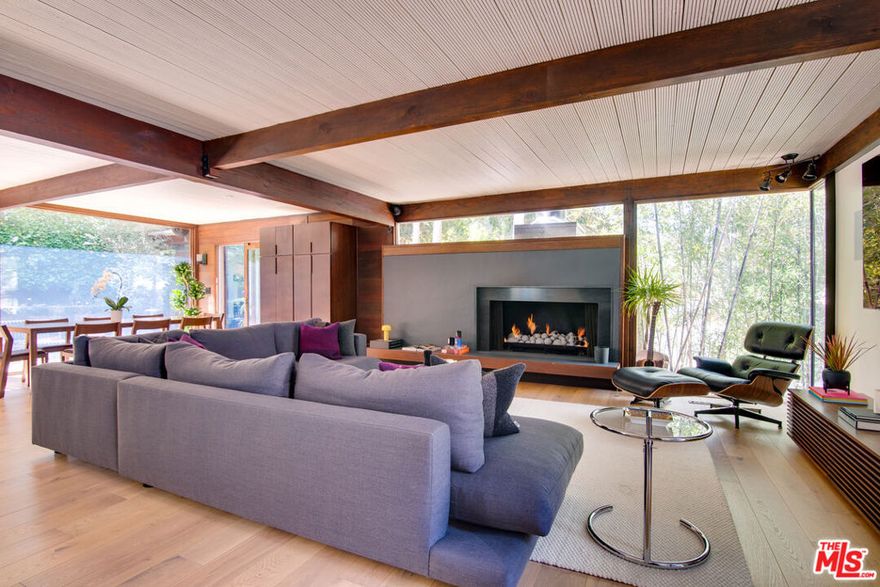 A mid-century jewel box with a separate music studio, constructed in 1960, epitomizing architectural elegance and modern refinement. Meticulously renovated, it presents a harmonious blend of vintage glam and contemporary luxury. Upon entering, you are greeted by distinctive architectural elements emblematic of the era, including clean lines, expansive windows that flood the interiors with natural light, and an astute use of space.The open floor plan masterfully integrates the living, dining, and kitchen areas, creating an ideal environment for both sophisticated entertaining and everyday living. The gourmet kitchen, a culinary enthusiast's dream, features premium appliances, sleek countertops, and ample storage.The residence comprises three thoughtfully designed bedrooms and three bathrooms, each exuding comfort and style. The primary suite serves as a serene retreat, complete with a spa-like ensuite bathroom.The outdoor space is equally inviting, perfect for both relaxation and social gatherings. A detached studio offers versatile use, ideal as a gym or office. Additional amenities include a laundry room, two-car garage, and tandem parking. This is Beverly Hills living at its zenith.