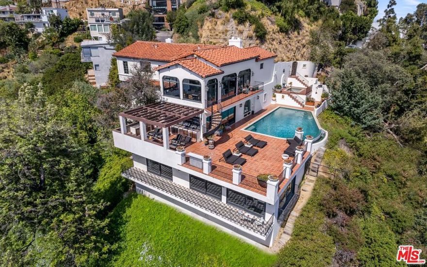 Stunning Spanish contemporary villa hovering over the Sunset Strip with drop-dead panoramic city & ocean views from every room. Interiors by Commune, this 3-story private estate hosts an open floor plan with a step-down living room w/a fireplace, gourmet kitchen, studio, exquisite bathrooms & massive entertainment room that spans the entire length of the home. Two-story spiral staircase w/ skylight leads to bedrooms, including a large private primary suite overlooking the lights of LA. Perched on the hills with explosive views, the enormous wrap-around tile deck features an infinity pool, spa, and covered entertaining area. "Welcome to Hollywood" the most iconic street in the world.
