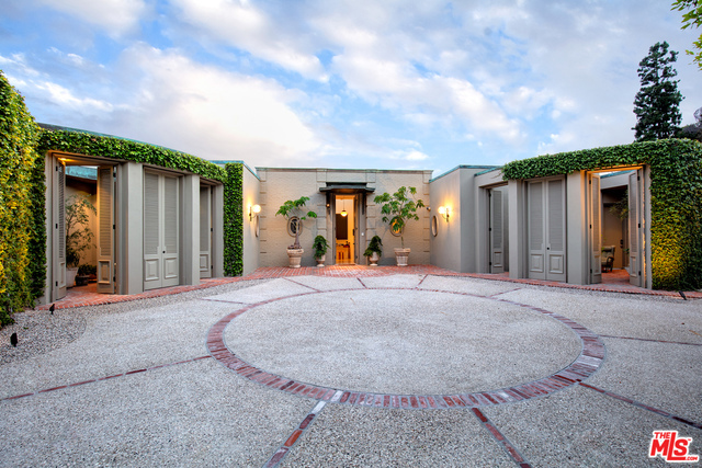 The epitome of style, taste, & architecture. Designed by John Woolf & completely restored & updated in 2019. Very chic and glamorous combining old Hollywood w/ modern amenities & luxury, all new systems/finishes. The home is a stunning example of the Hollywood Regency style w/ theatricality, elegant proportions, & dramatic details. Located in the best section of Trousdale Estates, the home offers breathtaking views from the grand living room, rear covered patio & outdoor areas w/ large bay windows & columns lining the curved patio area. Embracing the Southern California indoor-outdoor lifestyle, en-suite bedrooms each open through floor-to-ceiling sliding doors to a private courtyard/terrace, while the master ste w/ spa-like bathroom has access to both pvt courtyard & large outdoor areas for major entertaining. Completely private, walled & gated w large motor court. A unique property with city-to-ocean views, this is a rare opportunity to own an iconic John Elgin Woolf-designed estate.