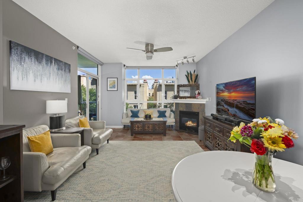 Welcome to Discovery at Cortez Hill. This pristine 2-bedroom, 2-bath residence in a contemporary luxury building designed for style, comfort, and convenience. With its clean modern finishes, open floor plan, and abundant natural light, this home offers a perfect balance of sophistication and livability. A cozy natural gas fireplace, roll down shades throughout, beautiful easy care tile flooring, and a private balcony makes the living area comfortable and relaxed. A modern kitchen with granite counters flows seamlessly into the living and dining areas, creating an inviting space for both everyday living and entertaining. The spacious primary suite features a spa-inspired bath and generous closet space, while the second bedroom is ideal for guests, a home office, or a den. The guest bath features custom tiled stall shower and granite counters. Full size washer/dryer is stacked for convenience. Residents enjoy 24-hour security and access to an array of high-end amenities, including a rooftop pool & spa with sweeping views, barbecue area and resort seating with fire-pits. A fully equipped fitness center with weight room, cardio, steam room and sauna plus thoughtfully designed communal space. Discovery at Cortez Hill is ideally located in one of the quietest neighborhoods in downtown. Little Italy, Petco Park, Gaslamp, and Balboa Park are all within walking distance. Freeway access to I-5 and 163 are 3 blocks away and you can be at the airport in under 15 min. Make this condo your urban oasis.