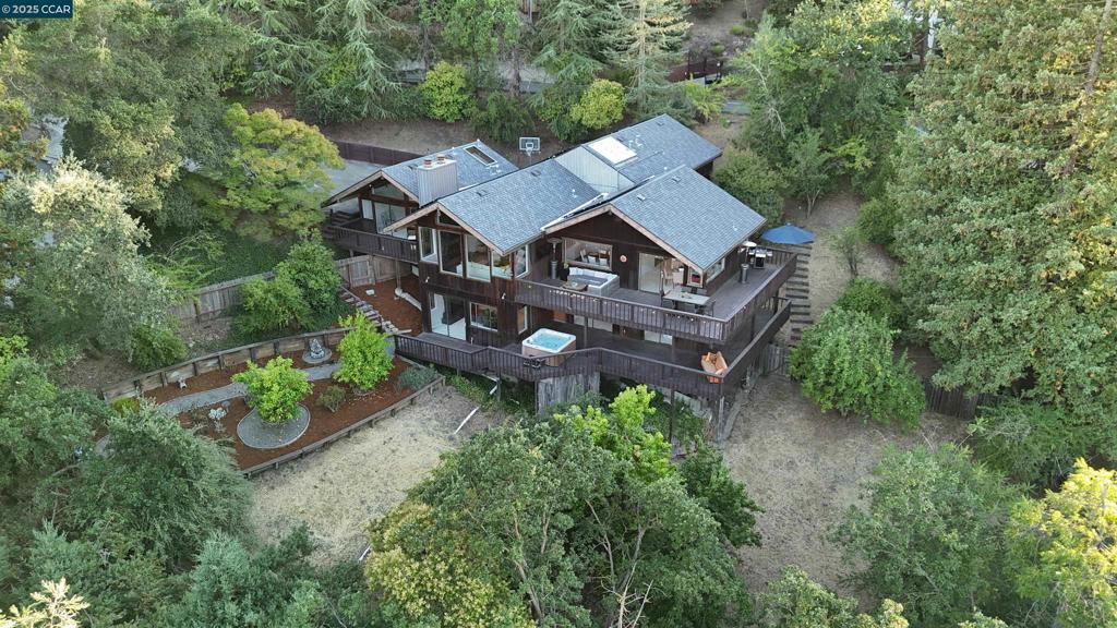 Experience the breathtaking alpine charm just minutes from downtown Walnut Creek and Lafayette. Nestled among mature redwoods in a peaceful secluded setting, this beautifully crafted cedar-shingled sanctuary offers inspiring views of Mt. Diablo and Acalanes Ridge. The main level is designed with effortless flow for both entertaining and everyday living. The light-filled living room boasts soaring ceilings, hardwood floors, large stone fireplace and wall of windows to take in the ever-changing panoramic views. The well-appointed eat-in kitchen has granite counters, stainless steel appliances, breakfast bar and opens to an impressive dining room as well as a large wrap around deck. The palatial primary suite offers vaulted ceilings, abundant natural light large private deck. Downstairs provides a perfect refuge with three large bedrooms, two full bathrooms and a second family room complete with brick fireplace, wet bar and direct access to the backyard garden and hot tub overlooking the hills The landscaped yard includes lemon, apple and plum trees. Owned solar panels minimize electric bill. Centrally located near award-winning schools, open space and nearby trails, shopping, dining, community events, freeway access and more. Truly a rare and remarkable retreat! Special Financing