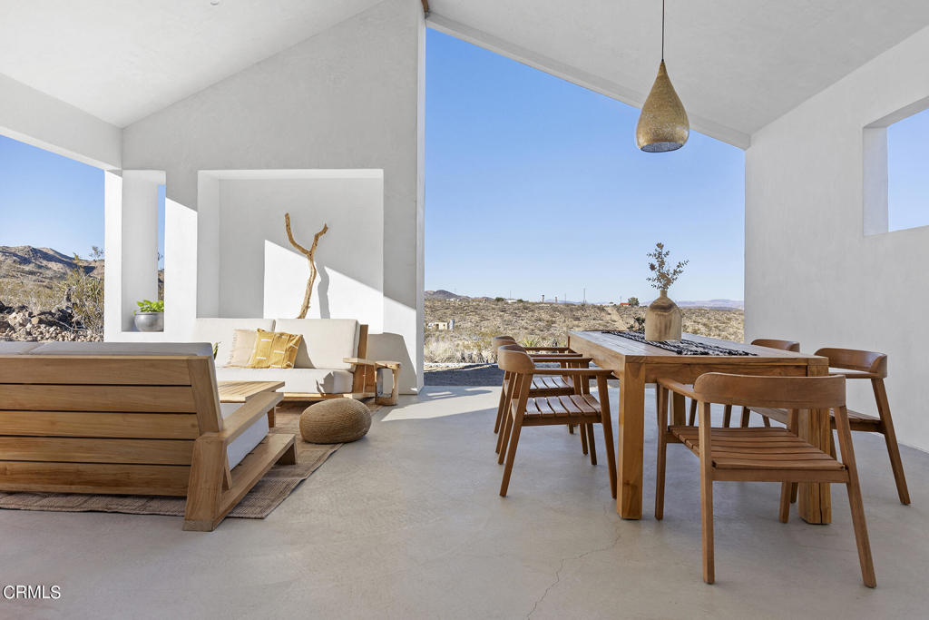 Built & designed by an award-winning design-build collective, 2340 Inca Trail is a fascinating piece of contemporary architecture. The home showcases the beauty of its surrounding landscape while paying homage to the area's history. It's situated on 5 acres of land with deep historical ties, chief among them being the ruins of an old mine entrance from the California Gold Rush days & private access to the Sand To Snow Monument which contains ancient pictographs by native inhabitants. By taking cues from surrounding homes and embracing the original homestead cabin, Inca Trail's garden rock walls, benches, and pedestal base were made from the site's abundant volcanic lava rock. Through its thoughtful open design, this modern cabin is in peaceful contemplation of the surrounding mountains. It boasts 10' ceilings, 8' solid interior doors, concrete floors, Fisher&Paykel appliances, and custom plaster built-ins with vintage reclaimed wood shelving throughout. The primary suite includes an in-bedroom pedestal tub and both baths feature smooth plaster showers walls and custom vanities. Even with the energy efficient doors and windows and Wi-Fi enabled mini-split units, you'll be spending most of your time in the home's piece de resistance: an open air living/dining area that extends the home's usable footprint by nearly 500 square feet. Relaxing here offers truly jaw-dropping views of the grounds, including a sitting area with a built-in natural stone banquette and a solid wood hot tub with wood burning heater. 2340 Inca Trail is just minutes from La Copine, Giant Rock Meeting Room, Moon Wind Trading Co, Pioneertown, Pappy + Harriets, and the Pipes Canyon Preserve.