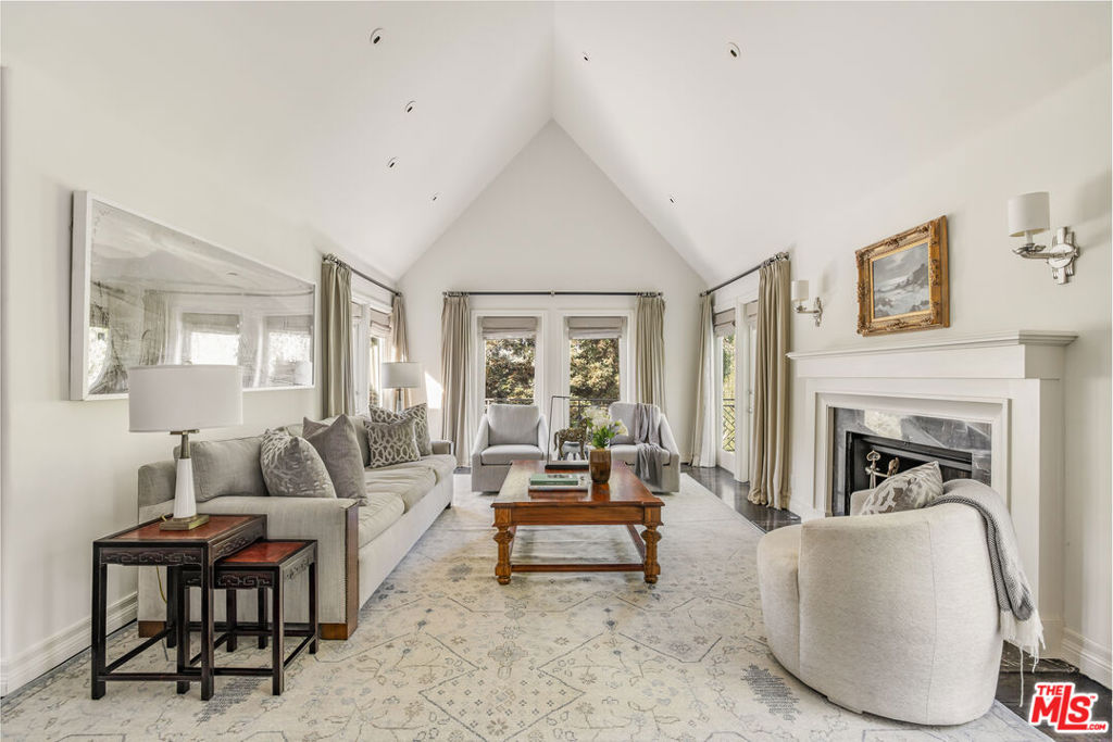 A timeless and turn-key residence in the City of Beverly Hills. Just one mile north of Sunset Blvd, this elegant home sits on a quiet cul-de-sac off lower Benedict Canyon. With five bedrooms and five and a half baths, the three-story home offers a flexible layout with ultimate privacy and wonderful city and mountain views. At the heart of the home lies a serene, garden courtyard visible from all the main rooms. Up a short flight of stairs from the foyer, the main floor is connected by a sunny and gracious hallway. Here you'll find a spacious, sunken family room and wet bar, a well-appointed eat-in kitchen, a formal dining room, living room, office, powder room, and a staff bedroom & bath tucked away behind the laundry room. On the top floor is a primary bedroom featuring dual bathrooms, two walk-in closets, and two private balconies which incredible views. Another upstairs bedroom with en-suite bath is currently used as an office. The lower level is dedicated to entertainment with a spacious TV room and a pool table. Two more bedrooms (one currently used as a gym) and a full bathroom with a steam shower complete this level. Outdoors, you'll find a beautifully landscaped courtyard, offering private space for relaxation, entertaining, and dining. A two-car garage, walk-in security gate, and locked gardener entrance offer ultimate security. This Beverly Hills classic is the perfect blend of timeless elegance and modern comfort.