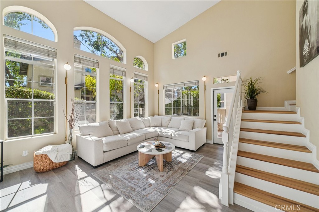 Welcome to this beautifully upgraded 3-bedroom, 3-bath end-unit townhome-style condo in the heart of Rancho Santa Margarita. Recently refreshed throughout, this move-in-ready home offers a light and airy floor plan with modern finishes and thoughtful upgrades at every turn.
A highly desirable downstairs bedroom and full bath provides comfort and flexibility for guests or a home office. The spacious living and dining areas feature a renovated fireplace and flow seamlessly into a private outdoor patio—perfect for entertaining, gardening, or simply relaxing in the California sunshine. As an end unit, the home enjoys extra privacy and natural light.
The fully remodeled kitchen showcases painted cabinetry, quartz countertops, a stylish backsplash, an upgraded sink and faucet, and a pantry with added storage. Premium appliances include a Samsung smart refrigerator with Family Hub, smart oven, Bosch dishwasher, plus a Samsung washer and dryer. The laundry room has additional cabinets for convenience.
Upgrades extend throughout the home, including luxury vinyl plank flooring, new baseboards, upgraded stairs, fresh interior paint, modern stand-alone light fixtures, and premium switches, plugs, and lighting. Every bathroom has been tastefully renovated with new sinks, faucets, mirrors, fans, toilets, shower heads, and flooring. The luxurious primary suite features a customized walk-in closet, built-in double vanity with smart mirror, and a spa-like bathroom with barn door entry, premium tile finishes, a European rain shower, and glass enclosure.
Additional highlights include: Full-house water filtration system with reverse osmosis, Lighted modern ceiling fans in every room, 3-year-old HVAC system and water heater, Fully paid Vivint security system, New garage door mechanisms, Professionally installed 48A Level 2 EV charger, Patio upgrades with new sprinklers, timer, palm tree, and flowers.
Conveniently located near parks, trails, shopping, dining, and Rancho Santa Margarita’s highly rated schools, this stunning end-unit offers the perfect blend of comfort, style, and modern amenities.