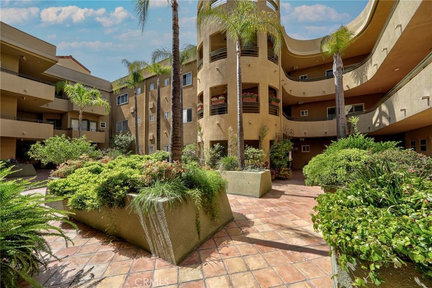 A luxurious, stately condominium in a high-end residential neighborhood boasting designer’s made elements. It’s rare, super spacious 2015 sq.ft. condo privately tucked all the way in the back w/ soothing views of greenery & mature trees.  As you enter through the double-door entry, your eyes land on a dramatic living room w/ high ceiling, custom built fireplace, 2 balconies and a 20 ft. custom designed entertainment center. Next to it is an elegant Formal Dining Room that can easily seat over a dozen guests – perfect of entertaining or family gatherings. The formal dining room has tray-ceiling and subtle custom lighting. Cooks’ kitchen has high-end appliances, Caesar-stone counters and opens to a breakfast dining area. We have 2 spacious en-suite bedrooms. The primary bedroom has a stylish custom-designed fireplace, 2 gigantic walk-in closets, artistically designed paint, a private terrace and a sumptuous en-suite bathroom with soaking tub & shower, double sinks and make-up station. Amenities include: Pool, Gym, a Club- House, private storage unit, Side-by-Side parking, 8 guests parking spaces, EQ insurance. Location is unparalleled: a brief ride to Beverly Hills via. Coldwater Cyn. or hop on Hollywood Fwy just a few blocks away. For evening walks: enjoy this residential neighborhood's amazing properties.