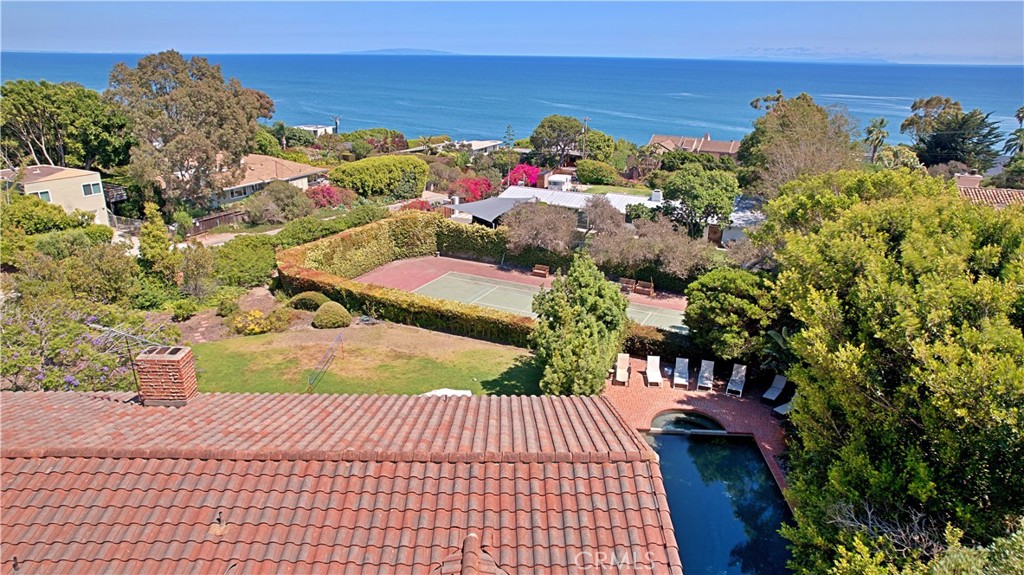 Just a short walk to one of Malibu's most beautiful beaches is this private and gated two-story Point Dume home with ocean views from just about every room. This five bedroom/three bath home includes a main level formal living room with fireplace, high ceilings and glass/wood sliders to a panoramic ocean view entertainer's deck, a formal dining room, large fireplace, family room, a granite island kitchen with eat-in area and a en-suite bedroom w/private wood deck. The lower level boasts an ocean view suite with a fireplace, high ceilings, glass/wood sliders open onto a covered patio, two spacious closets, a dressing area with custom shelves and a gorgeous blue tiled shower bathroom, plus three additional bedrooms. The landscaped yard, has a large grassy lawn and a smorgasbord of fruit trees, outbuilding (hut), pool/spa, fire pit, tennis court and an enclosed veggie/herb garden area. There is a 3-car garage and ample guest parking. Heated pool and spa, tennis court, badminton net. Walk to the award-winning Point Dume Elementary School. Dine in the quaint village and do your grocery shopping. It is a retreat on the sea. Showings begin August 24, 2025.