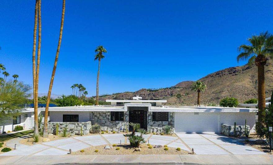 Welcome to Canyon Estates, a distinguished community renowned for its mid-century architecture in South Palm Springs. This executive home, designed by acclaimed architect Charles DuBois, showcases exceptional mid-century modern design elements including high ceilings, clerestory windows, and expansive walls of glass that seamlessly integrate indoor and outdoor living spaces .The property offers panoramic mountain views, a pool, hot tub, and several leisure areas on an expansive, private lot. A gated entryway opens to an elegant floor plan comprising 3,137 square feet, remodeled with contemporary features and conveniences. Notable upgrades include new driveways and walkways, updated gates, and 23 owned solar panels with backup battery support. The roof was replaced in 2019. Additional highlights feature porcelain tile flooring, new sliding doors, double-pane windows, a comprehensive water filtration system, and a gourmet kitchen equipped with a Cambria Quartz island, G.E. Monogram Series appliances, and custom cabinetry. The spacious living room boasts a floor-to-ceiling custom fireplace and direct access to outdoor patios, ideal for entertaining. The primary suite offers stunning mountain vistas and includes a luxurious bathroom with a granite walk-in shower. The well-designed layout encompasses four bedrooms, three and a half bathrooms, a formal dining area, laundry area, and a two-car garage. This property is situated on fee land, providing added value. Select furnishings may be available under a separate agreement outside of escrow. Homeowners Association amenities include access to a nine-hole golf course, clubhouse, fitness center, and tennis/pickleball courts. Call for your private showing today!
