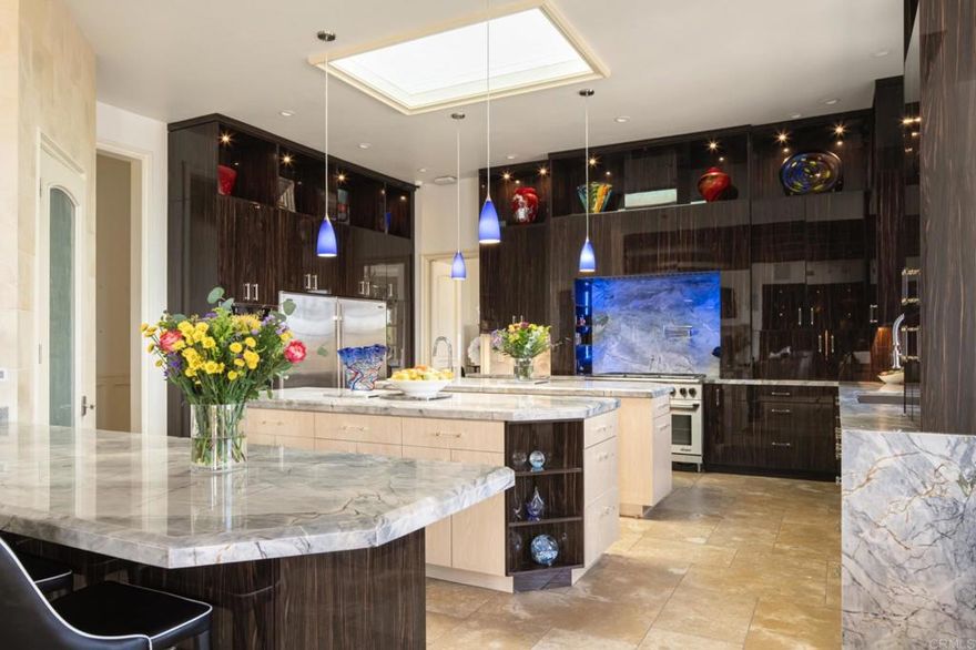 Now offered at an exceptional value, this 4.1-acre private, endless view estate within the prestigious 24-hour guard-gated community of Rancho Del Lago represents the pinnacle of resort-style living. Thoughtfully reimagined and fully renovated, the single-level, 11,893-square-foot residence was designed to bring together timeless architectural elegance with modern functionality—ideal for families of all sizes seeking both connection, privacy and sustainable living. From the moment you arrive, a grand gated entry opens to manicured grounds where lifestyle amenities unfold at every turn. A lighted tennis court, bocce ball, and an oversized infinity-edge pool with spa and pavilion provide endless opportunities for recreation and relaxation. Multiple covered terraces, outdoor fireplaces, and a full outdoor kitchen create elegant venues for gatherings, from casual afternoons to grand-scale entertaining. Mature colorful landscape frame the never-ending view while bountiful, organic fruit and vegetable gardens provide the residents with seasonal meal-time delights. Inside, the residence was planned with flexibility in mind. The main living, dining and family rooms are complemented by an arcade/game room and gym, and a detached, sophisticated guest house with living room, bedroom kitchenette and bath, allowing for simultaneous activities with effortless flow. The chef’s kitchen, anchored by slab Brazilian quartzite countertops and custom cabinetry, seamlessly connects to the family room and outdoor living spaces.  Seven en-suite bedrooms, including a whimsical “castle suite” for younger family members, are designed to provide privacy and comfort across generations. Two executive offices cater to work-from-home needs, while a secondary kitchen and private entrance create a dedicated wing for staff, extended family, or multigenerational living.  Two oversized garages accommodate up to eight vehicles, enhancing both function and convenience for collectors or families with multiple drivers. 6565 Calle Reina is more than a residence—it is a legacy estate designed for modern family living. Every space balances elegance and livability, creating a sanctuary where memories are made and lifestyles are elevated.