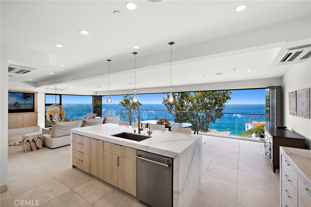 Perfectly perched on the bluff above Victoria Beach, this fully furnished contemporary Laguna Beach residence captures sweeping, unobstructed views of the Pacific Ocean, crashing whitewater, dramatic coastline, and shimmering Catalina Island sunsets. From the moment you arrive, the allure of the sea is ever-present—the soundtrack of waves against the shore and the scent of salt air create an atmosphere of effortless coastal luxury. Spanning approximately 3,055 sq. ft., the 4-bedroom, 4.5-bath retreat blends clean modern lines with inviting warmth. Floor-to-ceiling windows frame the horizon, drawing natural light deep into the home and seamlessly connecting indoor spaces with the boundless ocean just beyond. The chef-inspired kitchen is both functional and refined, outfitted with Wolf, Bosch, and Sub-Zero appliances. Control4 home automation elevates convenience, integrating lighting, climate, entertainment, and security throughout the residence. All four bedrooms and a full laundry room reside on the same level, ensuring ease of living for family and guests alike. Designed for gathering and relaxation, the lower-level bonus room transforms into a private theater with a projector, perfect for immersive movie nights or spirited game-day experiences. Rare for this coveted location, the property also offers a two-car garage and four additional off-street parking spaces. Just steps from the sand and moments from the world-renowned Montage Resort, the home is also a short drive to Laguna’s cultural treasures—the charming shops and dining downtown, the Pageant of the Masters, and the Sawdust Festival. With flexible lease terms, world-class views, thoughtful modern amenities, and an enviable proximity to the shore, this residence is a rare coastal jewel along Laguna’s most treasured stretch of coastline.
