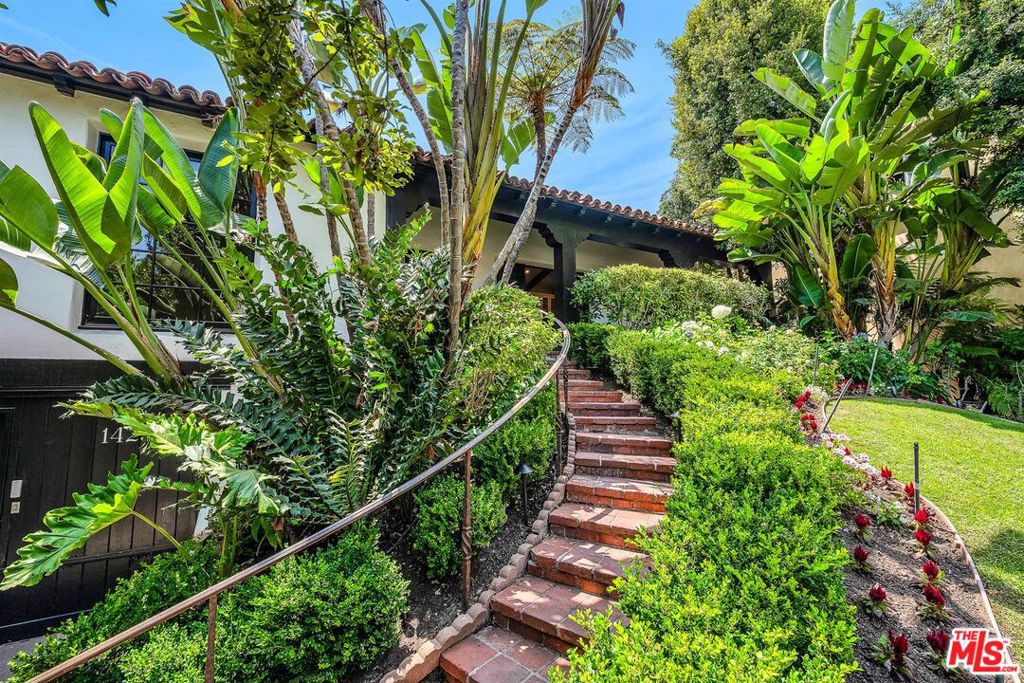 Beautifully restored Spanish Revival in Prestigious Comstock Hills. Welcome to 1423 Warnall Avenue, a unique and meticulously updated residence located steps away from the iconic Los Angeles Country Club, in one of LA's most coveted neighborhoods.This home is also located within the highly rated Fairburn Avenue Elementary School District. Originally constructed in the 1920s, this timeless 2-bedroom, 2-bathroom home also features a bonus convertible 3rd bedroom or office space with a serene and private outdoor view. This unique home blends classic architectural charm with extensive modern upgrades.Inside, the home offers a seamless balance of elegance and comfort. The spacious living room features dramatic beamed ceilings, a gas fireplace, original stained-glass windows, and a traditional tiled entryway that reflects its vintage heritage. The heart of the home is the large, fully remodeled kitchen, which impresses with its vaulted double-height ceilings, peaked by a customized stained-glass window that beautifully reflects sunlight onto the pristine Dolomite countertops. This open concept chef's kitchen is further enhanced by an elevated island featuring a built-in climate-controlled wine cabinet and an unobstructed view of the expansive dining and living room areas, ideal for entertaining. The apron-front sink is equipped with a filtered water system and an ever-ready chiller. The oven is a professional-grade, stainless steel Thermador with a six-burner gas cooktop which includes an industrial hood. A dedicated laundry room with oversized washer, dryer, shelving, and additional storage adds to the home's superior functionality.The kitchen flows seamlessly into the dining area, where French doors fill the room with natural light and open to a charming front patio, perfect for indoor/outdoor entertaining. Just off the dining space is the versatile bonus room, enclosed by glass doors that allow for either privacy or an open flow. This space also features a striking Versace-inspired guest bathroom and a sliding glass door that opens onto the backyard patio. The oversized primary bedroom boasts elegant, coved ceilings and a walk-in closet, while a stylish Jack-and-Jill bathroom connects the primary and second bedrooms, each with separate access for convenience and privacy.Perched above street level, the front yard enhances the home's privacy and curb appeal with a timeless presence. The lush, grassy front yard with rare tropical plants offers a peaceful oasis in the heart of the city. Additional features include a one-car garage with extra storage, plus driveway parking for two more vehicles. The property is perfect for a homeowner seeking charm and character today, with the added benefit of long-term investment potential. It is surrounded by multi-million-dollar new construction, offering development upside for those considering a custom build. Ideally located near Westfield Century City Mall, UCLA, Beverly Hills, Los Angeles Country Club, Holmby Park, this home offers the perfect blend of historical character, contemporary comfort, and unmatched convenience.