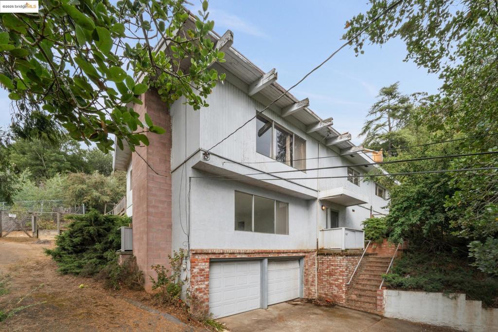 Fixer with midcentury vibes on a private street in sought-after Joaquin Miller! Owned by the same family for over 30 years, this home features clean lines, soaring ceilings, two fireplaces, partial bay views from the living areas and expansive deck, plus a two-car garage. With 2,700+ square feet of living space, the main level offers three bedrooms—including one en-suite—an additional bath, a voluminous living room, and a spacious kitchen and dining area that opens to a level sunny, outdoor space, creating that desirable California indoor/outdoor flow. The level in from street lower level features a living room, additional bedroom and bath, offering a multitude of possibilities for multi-generational living, a guest suite or extra living space. A peaceful retreat in a serene setting, yet just minutes from parks, trails, Highway 13, and Woodminster/Montclair offerings.