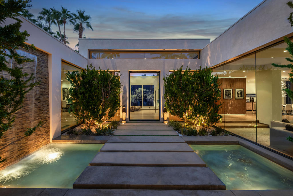 A tennis court estate property of incomparable proportions. Created by a team of top design professionals and of the highest quality. This 8 bedroom home offers an oasis of luxury on 4 lots in the renowned Thunderbird Cove. Built by Steve Chase. An entry courtyard of Jerusalem-limestone and 10 foot waterfall creates a gorgeous introduction to the residence with spans 10,000 square feet. Wide plank hardwood floors stretch from the formal entry into the dining and living area, also featuring pocket Fleetwood doors opening to the pool, chrome fireplace a reclaimed wood bar , and walls of glass that flood the space with natural light. The kitchen has Meile appliances and has glass windows that provide beautiful natural light. A huge lawn runs around the back of the estate backing up to the mountains. The main house has 5 bedrooms with an attached casita. There are two additional guest quarters - one is a very large one bedroom and bath with a kitchenette. The second has two bedroom and two baths. There is a clay tennis court which was recently resurfaced and is lit. This home has everything you need to enjoy the desert lifestyle to its fullest.