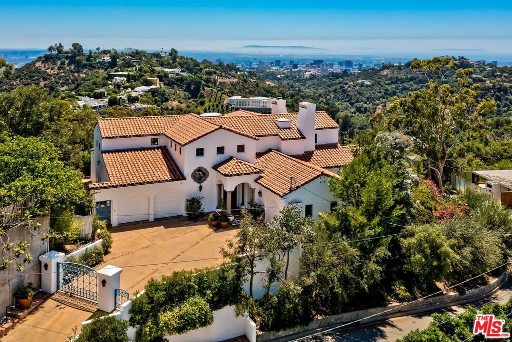 It's all about the views at this stunning Spanish style home designed by Marc Appleton. Unobstructed vistas welcome you immediately upon walking into the formal living room with sights of the Pacific Ocean, Catalina, the skylines of Century City and Downtown LA, as well as the canyons of Bel-Air. This wonderful floor plan offers two primary suites, perfect for guest privacy, with the main level suite conveniently tucked away from the living area. The newly renovated chef's kitchen is sleek and luxurious complete with top-of-the-line stainless steel appliances and a window looking out to the City lights below. An elegant media room and formal dining room complete the main floor. Upstairs find the main primary suite with a large walk-in closet, bathroom and wall of windows flooding the room with light. The second floor also has a home office and a second bedroom with its own bath, walk-in closet and sitting area with beautiful views. Notable architectural details throughout include arched doorways and windows, exposed beams, vaulted ceilings as well as Moroccan influenced tile and doors. The gracious patio, side yard and lower deck allow for al fresco dining and panoramic sunsets. Minutes to everything Beverly Hills and the West Side has to offer, yet high up enough to feel serenely peaceful.