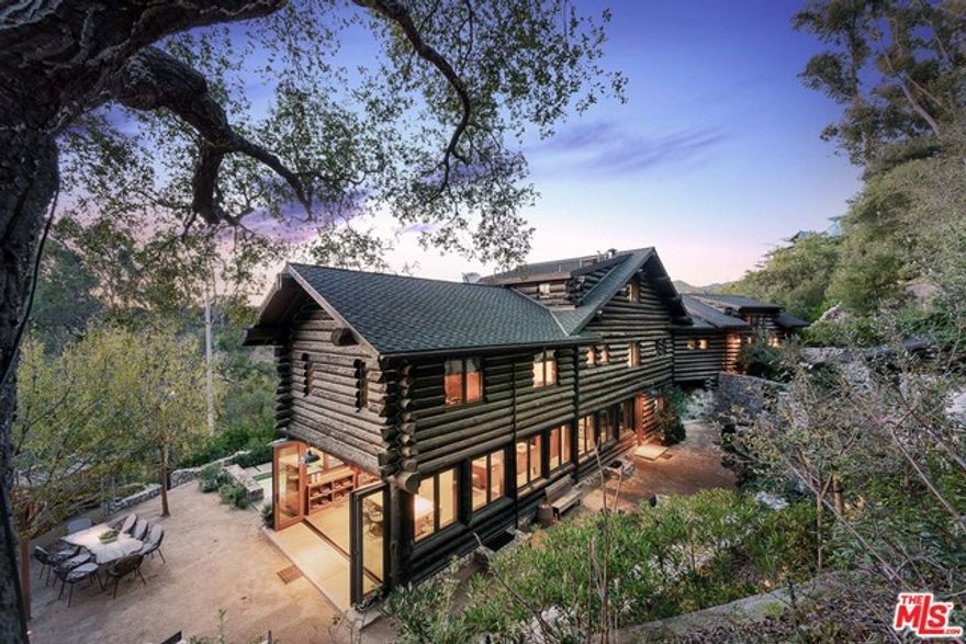 Tucked discreetly amidst the trees of the iconic Uplifters Ranch neighborhood of Rustic Canyon, this contemporary lodge-inspired home, recently profiled in C Magazine, sits upon a storied property that once served as a bohemian retreat for Hollywood icons. Modern finishes meet native materials throughout, such as naturally fallen lodgepole pine that form the home's framing in a striking fashion. The enchanting Great Room delivers warmth with its grand fireplace, the stones of which were meticulously dismantled from the original cabin, numbered and reassembled. A large open kitchen and dining room is hugged by double case windows and bi-fold doors, offering views of the outdoor entertaining areas, including a large terrace, plunge pool and stone paths undulating through the home's hillside park. Primely sited between the main dining and shopping corridors of Santa Monica and the Palisades, the home enjoys proximity to the community pool, tennis courts and Canyon Charter School.