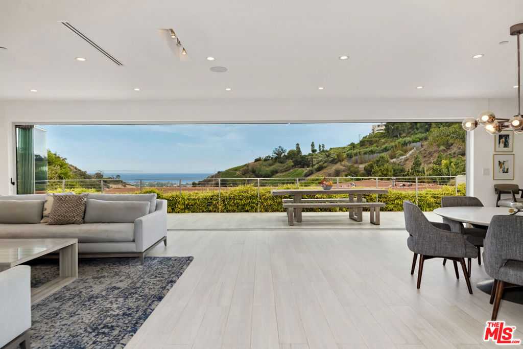 Set on one of the rare streets in Marquez Knolls that remained fully intact, this single-level architectural oasis offers a unique blend of privacy, natural beauty, and community. Surrounded by returning neighbors and hillside vineyards, the home feels like a secluded escape yet enjoys quick, desirable access to both the PCH and Sunset Blvd for an easy commute to Malibu, Santa Monica, and beyond. Enjoy nearby hiking trails, beaches, and canyon serenity all just minutes from city essentials. Inside, the open-concept layout seamlessly blends elevated design with everyday comfort. A stunning living room, chef's kitchen with Thermador appliances, and dining area flow through retractable glass doors to reveal sweeping ocean and mountain views. The backyard is made for relaxation and entertaining, complete with a view-facing patio, spa, and sport court all framed by Pacific Ocean and hillside views. Five bedrooms include a spacious primary suite with ocean views, dual closets, and a spa-like bath. Other highlights: Tesla EV charger, direct-access 2-car garage, smart home features, and expansive skylights that flood the home with natural light. Receipts for professional remediation provided upon lease execution.