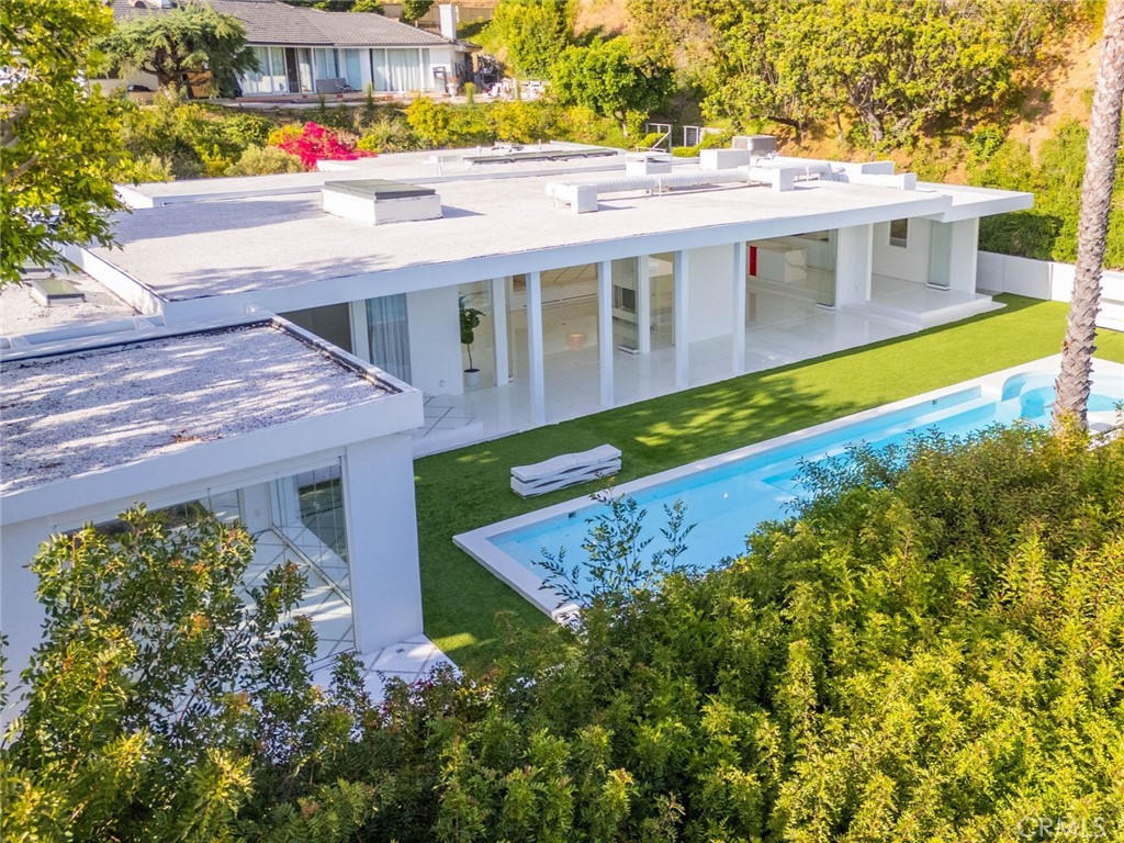 The pinnacle of luxury awaits at this exceptionally private residence in Trousdale Estates. Designed for the most discerning tastes, this oasis offers an unparalleled lifestyle. Inside, find quartz flooring throughout, Venetian plaster, custom Italian doors and skylights. The floor-to-ceiling glass walls fully open, seamlessly connecting to the outdoor pool and showcasing the 180-degree city and ocean views below. An entertainer's dream, the property boasts multiple outdoor lounges, an outdoor shower, and even an outdoor bonus room, all amidst lush landscaping and a tranquil courtyard. The interior features opulent bedrooms and bathrooms, a chef's kitchen with adjacent service kitchen and a living room with a double-faced fireplace. An elevated dining room sets the stage for exquisite meals. Indulge in the spa soaking tub, steam room and sauna. With every detail perfected for your enjoyment, you'll want for nothing in this lavish home.