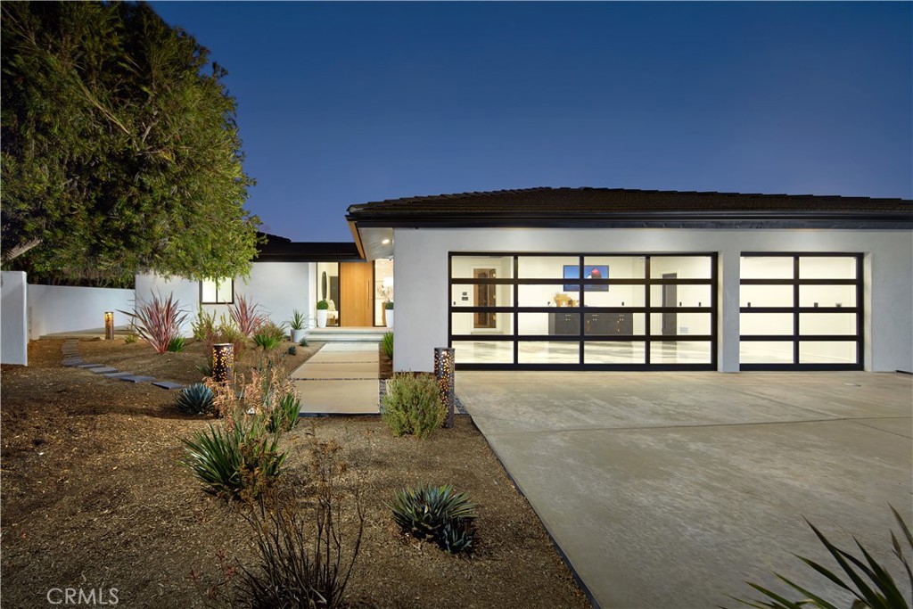 Tucked away on a cul-de-sac in Monarch Bay Terrace, this single-level 4 bed, 3.5 bath, appx. 3005 Sq Ft showpiece with panoramic ocean views has been fully reimagined, expanded, and redesigned. From the moment you arrive at the private extended driveway framed by lush, low maintenance landscaping, the home reveals itself as a rare blend of timeless coastal style and modern innovation. Step inside through a dramatic rift-cut white oak pivot door and discover wide-plank French oak floors, soaring 10-foot ceilings, and gallery-like proportions. Oversized WinDor glass doors frame uninterrupted ocean views, opening to an expansive terrace designed for seamless indoor-outdoor living. At the heart of the home, the kitchen balances form and function with a 10 foot Taj Mahal leathered quartzite island, custom oak rift-cut cabinetry with glass accents, and professional-grade appliances including a Thermador range, True commercial refrigerator, and Miele coffee station. A built-in bar with ice maker, sink, Thor beverage center and storage connects the kitchen, dining, and living spaces for effortless entertaining. The primary suite captures the coastline through picture windows and opens to a private terrace. The spa-inspired bath is finished with backlit Namibia Mystery Blue marble, a sculptural soaking tub, oversized rain shower, and dual vanities—all complemented by a fully customized walk-in closet. Two additional bedrooms share a designer bath, while a fourth bedroom suite offers flexibility as live-in quarters, guest casita or as a multi-generational living space with its own entry, ensuite bath, bar sink and private patio. Multiple lounges, TimberTech decking, stainless cable railings, and a built-in sound system create a resort-like setting with the Pacific Ocean as the backdrop. The three-car garage showcases reflective full-view doors, marble-look epoxy flooring, and EV-readiness, doubling as a stylish showroom. Modern conveniences abound with all-new plumbing and electrical, tankless water heater, high-efficiency HVAC, whole-home automation, Sonos audio zones, and smart security, the residence delivers the peace of mind of new construction with the warmth of thoughtful design. 23262 Ellice Circle is more than a remodel—it’s a complete re-invention of the coastal California lifestyle, where luxury design meets everyday comfort against a backdrop of panoramic ocean views.