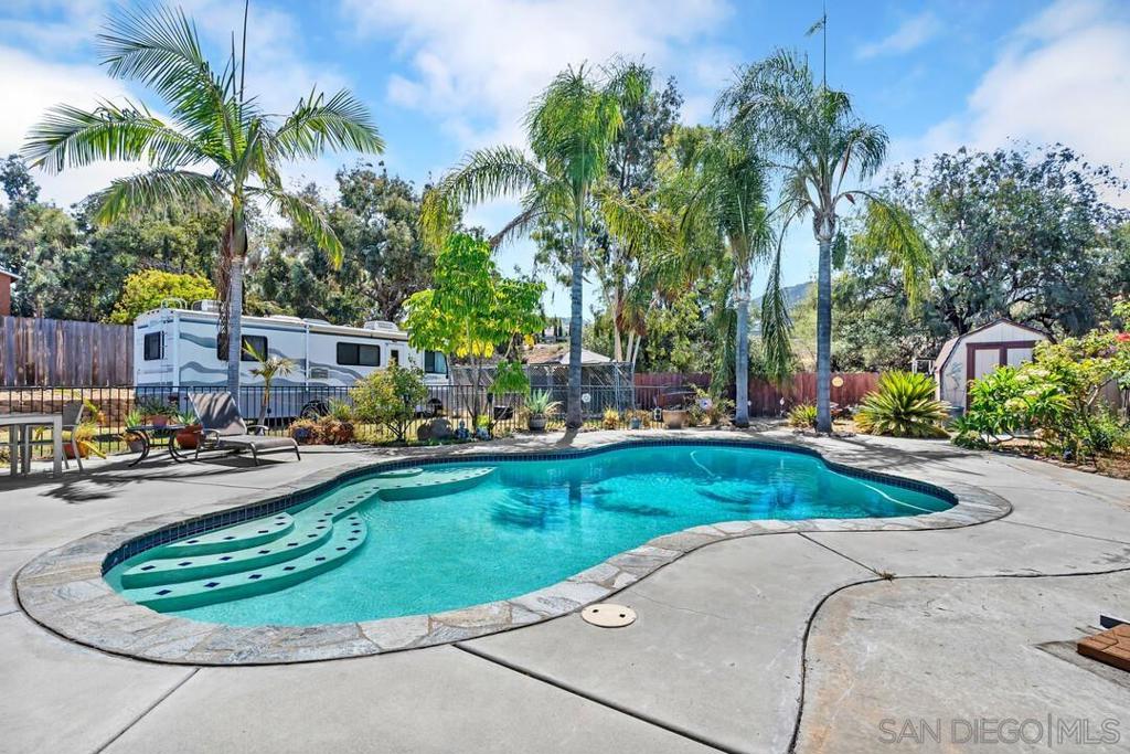 Backyard Oasis with Pool, Owned Solar & ADU Potential! This is the one you’ve been waiting for! Perfect for a family or starter home, this property sits on over ¼ acre and is all about outdoor living. The backyard is a true retreat with a sparkling pool framed by tropical palm trees, a large patio with bar-top seating, and plenty of space for entertaining. With its generous lot size, there’s also room for a potential ADU—ideal for guests, extended family, or rental income. Additional highlights include a large side yard perfect for RV parking or storage, and owned solar to keep energy costs low. Inside, the home offers 3 bedrooms, 2 bathrooms, plus a versatile bonus room that could be a family room, game room, or extra bedroom. You’ll also find luxury vinyl plank flooring throughout. You wont want to miss out on this one!