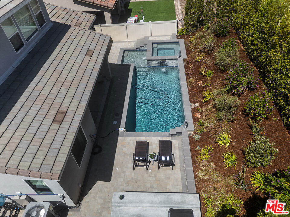 $25,000 Seller Credit for this Luxury Living Home with a Private Pool in Santa Clarita's Highly Coveted Skyline Community. Step into this exceptional, nearly-new residence where comfort, style, and sophistication converge. Built in 2023, this is a thoughtfully designed home with high-end finishes and elegant touches throughout, a 4-bedroom home which also features a dedicated office space, a loft ideal for a sitting area, theater or additional workspace, and 2.5 bathrooms. This home also has a fire suppression sprinkler system. From the moment you arrive, soaring ceilings and a striking iron staircase with a rich brown oak banister set the tone for the home's refined aesthetic. The first floor boasts a luxurious primary suite complete with a spacious walk-in closet and a spa-like ensuite bathroom, offering a tranquil retreat from the everyday. At the heart of the home lies a beautifully crafted kitchen featuring stainless steel appliances, sleek dark brown shaker cabinets, gleaming quartz countertops, a generous walk-in pantry, and an expansive island perfect for gathering and entertaining with ease. The open-concept great room invites connection and comfort, with custom built-in cabinetry and bar shelving, a sophisticated dining area, and a spacious family room designed for both relaxed living and memorable hosting. From the great room or directly from the primary suite, step outside to your own private backyard oasis. Designed with serenity in mind, this Zen-inspired retreat features a custom pool, rejuvenating hot tub, a built-in outdoor kitchen and lush landscaping that provides the ultimate in privacy and relaxation. A stylish powder room with custom tilework completes the downstairs, while the upper level offers a versatile loft, three additional guest bedrooms, and a full bathroom ideal for family, guests, or flexible living needs. This home is also a model of energy efficiency, equipped with OWNED SOLAR, ensuring sustainable living without compromise. As a resident of Skyline, you'll enjoy access to resort-style amenities including sparkling community pools, a fitness center, scenic paseos, and more. Discover elevated living in Santa Clarita where thoughtful design, modern comforts, and luxury amenities create the perfect place to call home. Seller is offering a $25K credit with offer of full asking price.