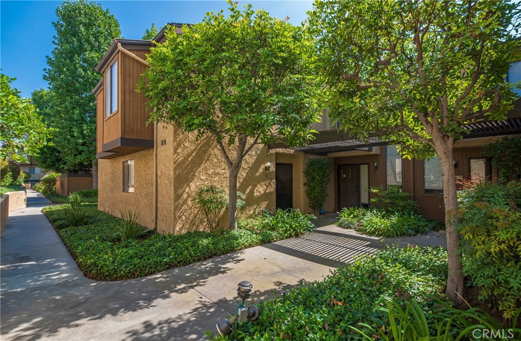 This two-story condominium, nestled within a desirable gated complex boasting lush, meticulously maintained grounds, presents an exceptional opportunity. Awaiting your personal vision, this cosmetic fixer offers a spacious and functional layout. The main level features a generously sized living room anchored by a fireplace, with a sliding door providing access to a private patio—ideal for relaxed outdoor enjoyment. The adjacent kitchen offers ample cabinetry and flows seamlessly into a dedicated dining area. Practical amenities on this level include a laundry area and a convenient powder room. The second level is dedicated to rest and privacy, housing two complete bedroom suites. Comfort is ensured year-round with central air and heat. Additional features include a detached two-car garage. Residents of this complex benefit from a sparkling swimming pool and the peace of mind offered by the secure, gated environment. The location offers convenience, situated just a short distance from the vibrant shops and restaurants of Old Town Monrovia, the local Library, a park, and a grocery store.