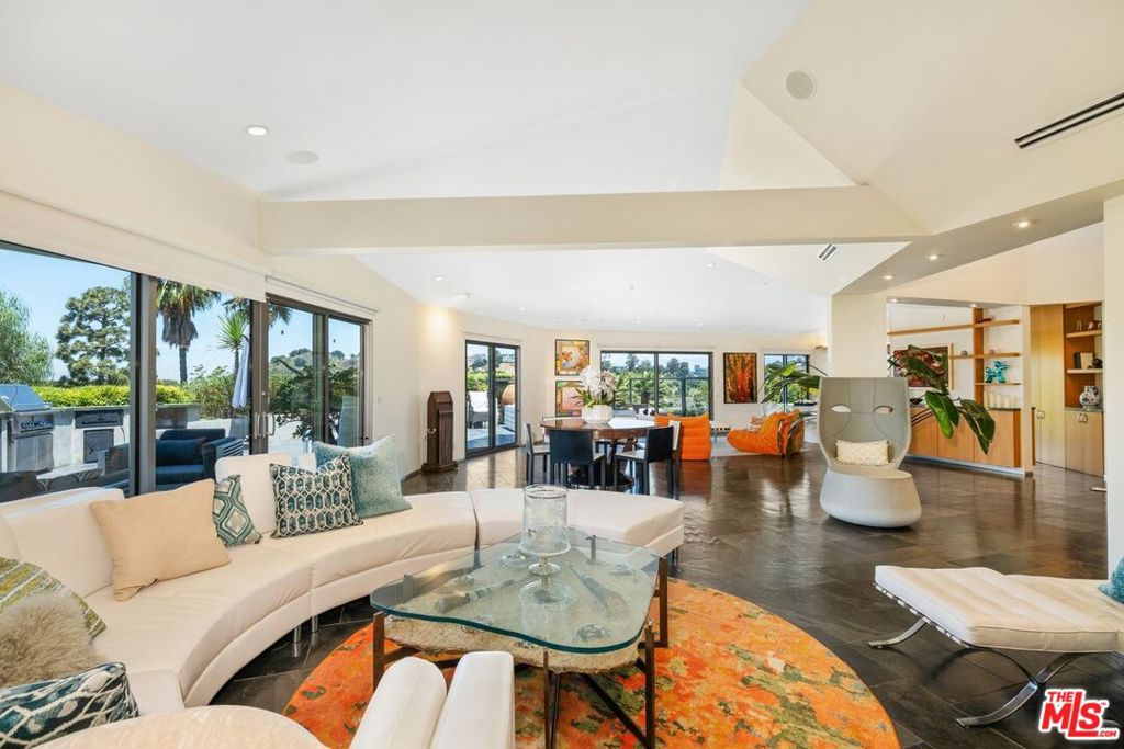 RESORT-STYLE HIDEAWAY WITH ABSOLUTE PRIVACY AT THE TOP OF A MOUNTAIN IN THE HOLLYWOOD HILLS. As you arrive at the end of a private road, tranquility sets in. The gates open to reveal a contemporary estate perched high on a hilltop promontory. Step inside and sweeping canyon views immediately remind you that you're above it all. Polished stone floors guide you through nearly 3,000 square feet of curated luxury, where light pours in through massive sliding glass doors. The modern kitchen flows into the living space, blurring the line between indoors and outdoors. Step onto one of several private terraces and hear the soft sound of a waterfall drawing you deeper into the retreat. Three spacious bedrooms, including two primaries, each feature ensuite baths and private vistas. The loft offers a serene nook for reading, working, or simply taking in the landscape, and can also serve as a fourth bedroom. A discreet safe room provides peace of mind, while upscale finishes highlight thoughtful design and attention to detail. Outdoors, lush landscaping frames multiple lounge areas that feel like secluded cabanas. At the center is a dramatic infinity-edge lagoon pool with a two-story waterfall and spa. Whether it's a morning swim, an afternoon of sunbathing, or an evening entertaining under the stars, the setting offers unmatched peace and indulgence. This isn't just a residence, it's a private sanctuary above Los Angeles, where every element has been designed for comfort, security, and style. Don't miss the opportunity to experience true resort living in the Hollywood Hills. Available fully furnished for lease.