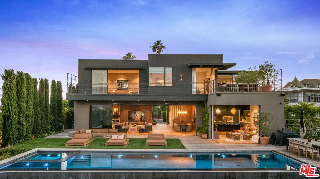 This stunning contemporary estate with sweeping 360-degree views is sure to take your breath away the moment you arrive. Perfectly positioned on one of Bel Air's most desirable corridors, 1030 Somera is a design-forward residence that redefines California luxury living. Expertly crafted by HEH in collaboration with Van Studnitz Architects and Studio Preveza, this gated home boasts grand scale, a warm mid-century aesthetic, and extraordinary quality throughout. Expansive windows frame panoramic views of the ocean, city, and canyonsoffering unforgettable sunrises and sunsets from nearly every room. Organic textures and clean architectural lines create a serene, modern atmosphere across the open floor plan, evoking a relaxed yet sophisticated ambiance. Floor-to-ceiling glass doors offer seamless indoor-outdoor flow to expansive terraces, a 50-foot infinity-edge pool, and a peaceful hillside garden filled with citrus trees, French lavender, and Tuscan rosemary.The six-bedroom layout includes a showstopping primary suite with a cozy sitting room, an oversized private balcony, and a spa-level bath. Three additional guest or children's suites are also located on the upper level. The main level welcomes you with mesmerizing views and features a dramatic living and dining area, a family room, and a state-of-the-art kitchen. The lower level, bathed in natural light, includes a home theater, gym, and guest quarters with a private entranceideal for hosting or extended stays. Every space is curated with a gallery-like aesthetic, perfect for displaying art while remaining warm and versatile for both entertaining and daily living. Additional highlights include a three-car garage and a gated motor court for ample parking. Private, polished, and perfectly situated, this one-of-a-kind residence offers the ultimate "Wow" factora rare opportunity to live above it all, just five minutes from Sunset and all the best the Westside has to offer.