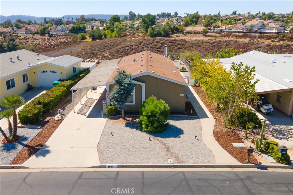 ***Charming Turn-Key Home located in the Heart of Murrieta's Premier 55+ Community - Warm Springs Knolls. YOU OWN THE LAND! Low HOA Dues! Low Taxes. This 2008 Manufactured Home on a permanent foundation is located in the Warm Springs Knolls Community. Walking distance to The Club House that offers resort style amenities, is designed to enrich the lifestyles of active seniors. The Club House includes - Kitchen, Meeting Room, Ballard Table Swimming Pool, Enclosed Spa, Showers in Restroom, Exercise Classes, lots of Social Events and Activities. This single story, 3 Bedrooms, 2 Bath home is ready to move in. As you enter the Front door into the spacious Livingroom a beautiful fireplace that warms the entire home. Kitchen has New Stainless Steel Appliances-as of 2022 - Refrigerator, Stove and Dishwasher, Beautiful Wood Cabinets spacious countertops. This Kitchen is a Chief Gourmets' dream come true! Spacious Eating Area with lots of Natural Light! Primary Bedroom is it own retreat, very spacious and opens into its own private bathroom. Two other bedrooms -would be perfect for an Guest room, Office or Hobby room. The Separate Laundry Room includes Washer & Dryer purchased in 2022. The Flooring is neutral color Wood Laminate throughout the entire home for easy care.
Chain-link fenced surrounds the Backyard - Easy Care - Hardscape 3 different rock colors invites your imagination for the outdoor living ideas and peaceful enjoyment to watch the beautiful Stars and Sunsets over the City and Hills of the City of Murrieta. Plus you're minutes from shopping, dining and easy freeway acess for added convience. CALL - Make an Appointment to Come See Your Forever Home today!
