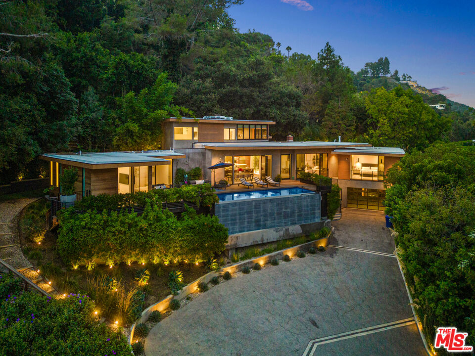 Available for lease starting September 1st, showings available beforehand. Welcome to your urban oasis nestled in the Holmby Hills, less than a 3-minute walk to Harvard Westlake. This architectural gem, born anew in 2018, effortlessly marries sophistication with functionality, offering a haven of tranquility within its sprawling 26,000 square feet of meticulously manicured grounds. As you approach, prepare to be enchanted by the allure of grandeur as striking wooden gates welcome you into your own private sanctuary. Beyond lies a veritable playground for automotive aficionados, boasting a regal 12-car motor court alongside an additional 6-car garage. Nature's embrace envelops the property, with majestic trees and verdant foliage lending an air of serenity and beauty to every corner. Step through the threshold and be greeted by soaring 12-foot ceilings that imbue the space with an ethereal ambiance, seamlessly guiding you towards the heart of the home. Within, discover a chef's kitchen adorned with top-of-the-line appliances, beckoning culinary adventures. Adjacent, a dining area adorned with retractable glass doors invites the outdoors in, blurring the lines between interior luxury and exterior opulence. Retreat to the master suite, a sanctuary of indulgence boasting custom walk-in closets and a spa-like ensuite bath, where relaxation knows no bounds. As the sun sets, entertain in style amidst custom-built outdoor seating, accommodating up to 50 guests, or test your putting skills on the green. Unwind by the fire pits, take a refreshing dip in the infinity pool, or simply bask in the state-of-the-art A/V upgrades that cater to every entertainment whim. With a junior master suite and versatile bonus room, the possibilities are as endless as the California sky. This is more than just a residence; it's a testament to the art of living well, where every detail has been meticulously crafted to elevate your everyday experience. Welcome home to luxury redefined, where urban living meets resort-style indulgence in perfect harmony.