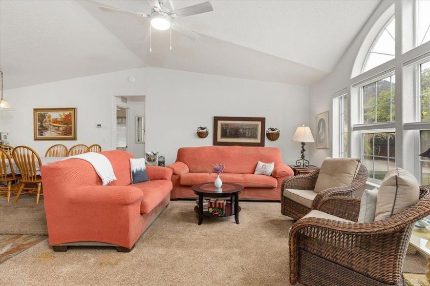 Welcome to this delightful home in a 55+ resident-owned “co-op share” community — no space rent or land lease fees!  Nestled on a large, corner lot with a rural feel, this property offers a peaceful retreat while still being conveniently located with easy access to highways 15 and 78.  This unique property features side by side parking for up to 3 vehicles and a detached studio cottage that could produce rental income or be used as a cozy guest room or hobby retreat - the possibilities are endless!  Note: Neither the studio cottage or the enclosed porch are being included in the listed square footage and therefore each provides additional usable living space!  The main home is s 2003 Hallmark manufactured home of a popular split bedroom floor plan, which provides space and privacy between the Primary Bedroom and two Guest Bedrooms.  The L shaped Kitchen has a long dining bar and is open to the Dining room and Living room.  There is a beautiful dormer window in the Living room that provides lots of natural light.  The washer and dryer convey in the indoor laundry room which also has a built in deep sink.  There are also 5 ceiling fans to circulate air, as well as central A/C if needed.  There is a handicap ramp for better access to the front door and both a front and back deck to enjoy the outdoors and nearby mountain views from!  The backyard is fenced and features 5 fruit trees, garden boxes, and turf.  You can also enjoy scenic views of nearby hills and nature from the high windows of the enclosed porch that let in plenty of natural light!  The studio cottage features a bathroom, kitchenette, fireplace, and wall A/C.  Deer Springs Oaks, Inc. is a small, 32 home HOA in which each homeowner owns 1/32 share of the entire community.  One person must be age 55+, a second resident can be 45+.  2 pets under 40 lbs are permitted.  Current monthly HOA fee of only $312 includes water and trash.   Buyer must qualify financially and meet certain minimum requirements with the HOA before purchasing.  Enjoy access to walking trails!  Peaceful, Friendly and centrally located in the beautiful North County of San Diego.  Everything you need is close by, easy access to highways 15 and 78, grocery stores, banks, restaurants, farmers markets, and Palomar and Kaiser medical centers and two hospitals. The small, friendly community offers quiet and privacy in an amazing setting.