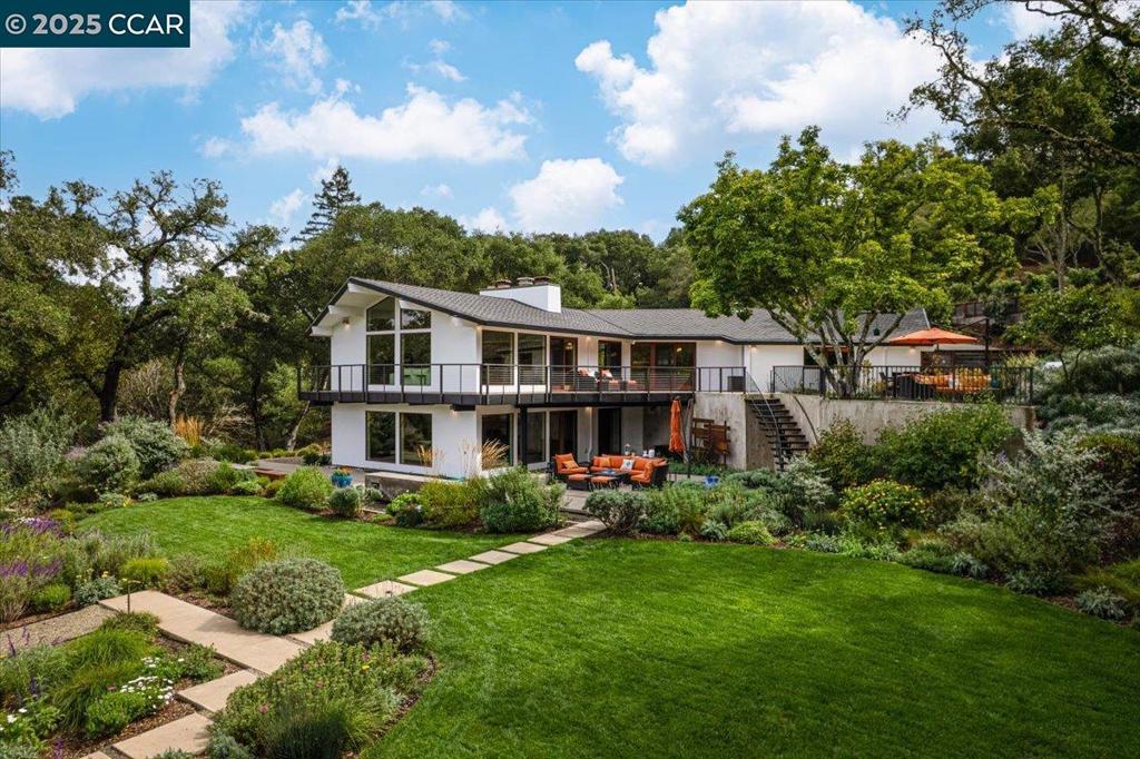 Mid-century modern meets contemporary with this stunning 5 bedroom, 4 bathroom home complete with floor-to-ceiling windows and open floor-plan. The 1.3 acre estate features an oversized-lawn, bocce court, modern fountain, outdoor kitchen, firepit and a mini-Filoli Garden with meandering paths filled with plants that bloom year-round! The remodeled kitchen has cathedral ceilings, a walk-in pantry, large island, Sub-Zero refrigerator and separate full-sized Sub-Zero freezer. Two bedrooms and bathrooms are on the main level (including primary suite), with 3 more bedrooms and a family room downstairs. There's even a separate air-conditioned studio in the yard. The 2-car garage is oversized with several other areas to park on the property at the end of a private cul-de-sac.