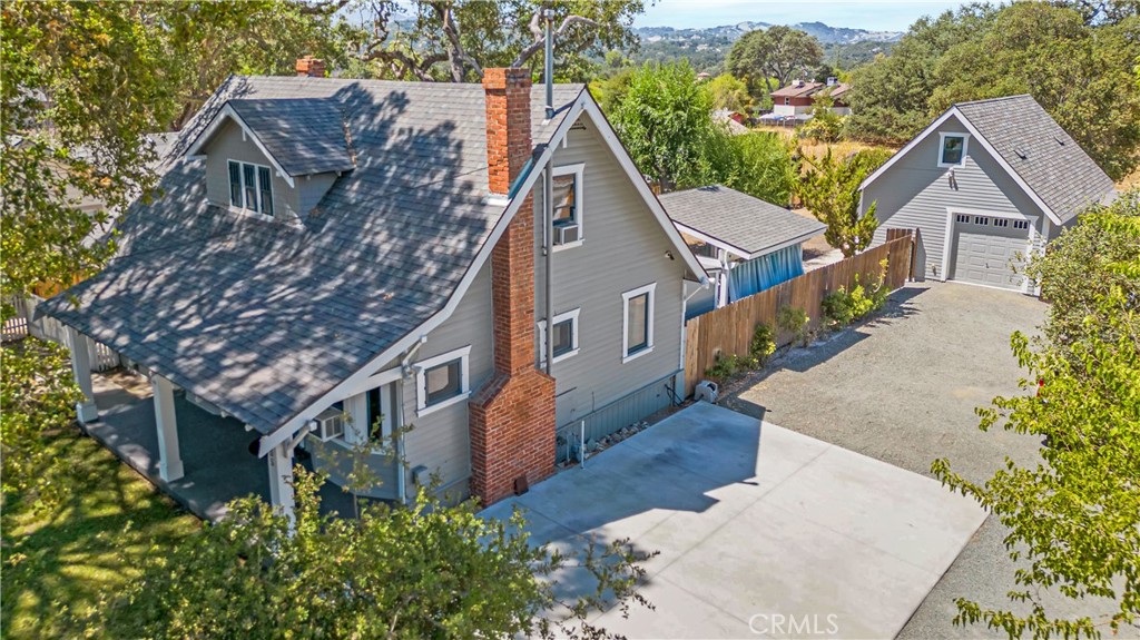 Welcome to 8955 Curbaril Avenue, a testament to Atascadero’s historic Colonial days! This one-of-a-kind designated Colony home—once owned by John Walsh and Lodi Kratz—stands as a timeless reminder of craftsmanship and character, beautifully preserved while thoughtfully upgraded for today’s modern living and includes a fully owned new solar panel system and battery back up. Set on nearly a quarter of an acre, this 4-bedroom, 1.5-bath residence is brimming with handcrafted woodwork, vintage details, and the unmistakable charm of the early 1900s. Step into the inviting living room off the large covered deck entry and how it leads through a formal dining area into the kitchen that flows seamlessly into an enclosed patio/laundry/sunroom, extending your living space into the outdoors. The private backyard oasis features an elevated Trex deck, covered patio, and majestic oaks that create a serene, partially shady, park-like feel ideal for relaxing or entertaining. Adding even more value, a detached garage was added ten years ago to match the homes aesthetic and appeal and for the music enthusiast has a fully finished music studio, an inspiring space for musicians, art creatives, or anyone seeking a private retreat. Upstairs, a finished loft, accessible via an exterior stairwell offers even more room to bring your ambitions to life. Whether you dream of a family home, a peaceful retreat, or a vibrant vintage sanctuary, this residence delivers it all. With a harmonious balance of history, craftsmanship and detail, 8955 Curbaril effortlessly combines old-world charm with todays modern efficiency.
