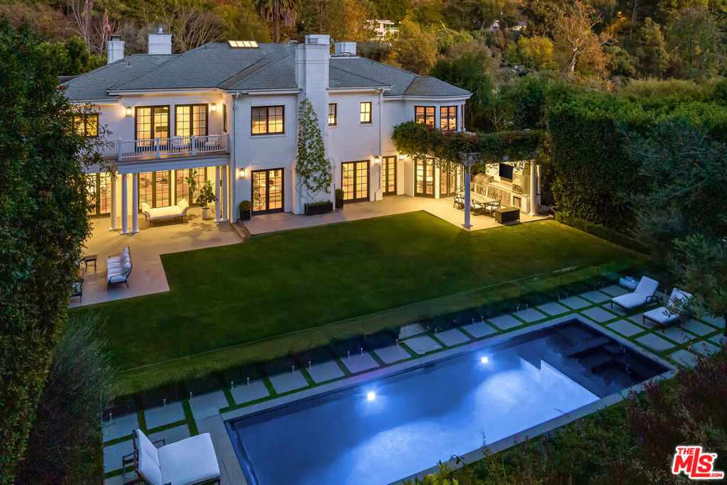 Tucked behind mature hedges and secure gates on prestigious Hazen Drive, this stately Georgian Revival estate offers the rare chance to lease one of Beverly Hills' most distinguished properties. Privacy is paramount here, with a gated driveway, expansive motor court, and a four-car garage. Inside, the home blends timeless architecture with fully updated, contemporary interiors. A double-height foyer welcomes you into light-filled living spaces designed for both grand entertaining and relaxed day-to-day living. French doors open from the formal living and family rooms to a lush backyard, creating an effortless indoor-outdoor flow. The chef's kitchen, complete with La Cornue range, butler's pantry, and breakfast area, connects directly to the outdoor dining patio for easy entertaining. Upstairs, the serene primary suite includes a sitting room with fireplace, private balcony, dual walk-in closets, and two spa-like bathrooms. Four additional en-suite bedrooms provide ample space for family or guests. A private library, screening room, fitness studio with sauna, and a spectacular lower-level lounge with billiards, bar, and wine gallery offer endless ways to relax and entertain at home. Outdoors, a flat lawn, sparkling pool and spa, outdoor kitchen, pizza oven, and fire pit lounge create a resort-like atmosphere. The manicured gardens, hillside vegetable patch, and multiple dining areas make it easy to embrace Beverly Hills' indoor outdoor lifestyle year-round. This exceptional residence is moments from world-class shopping, dining, and top-rated schools -- offering a rare opportunity to experience Beverly Hills living at its most refined.