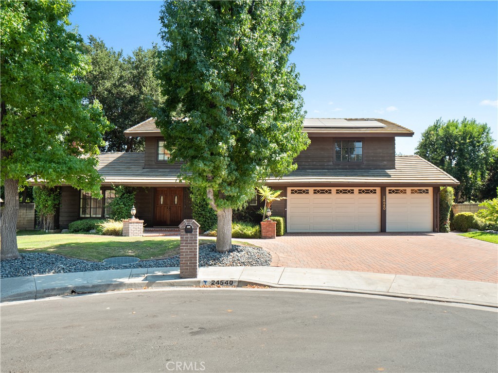 Welcome to this charming home located in the highly sought-after community of Happy Valley in Newhall. Nestled at the end of a quiet cul-de-sac, this property boasts beautiful curb appeal with mature trees providing ample shade, an oversized brick driveway, a spacious three-car garage and solar. Step through the double door entry into an expansive living room featuring beamed ceilings and a striking brick fireplace, seamlessly flowing into the formal dining room. The generous family room opens to a cozy eating area and a large kitchen complete with a charming bay window, abundant cabinetry, and extensive counter space. A convenient laundry room with extra storage, and powder room for guests completes the lower level. Upstairs, you’ll find a ginormous primary suite with a separate sitting area perfect for a nursery, home office or 4th bedroom, and an ensuite bathroom with a soaking tub and glass-enclosed walk-in shower. Two additional well-sized bedrooms share a full bathroom with dual vanities. Dual tree-lined yards with grassy areas, a spacious covered pergola patio, and a built-in cooking station—ideal for entertaining. Located in the heart of Newhall near Old Town Newhall Main Street, this home is close to parks, award-winning schools, restaurants, shopping, and offers easy freeway access. Best of all, there are no HOA fees and no Mello-Roos taxes. Don’t miss this amazing opportunity to become the second owner of this home!!!!