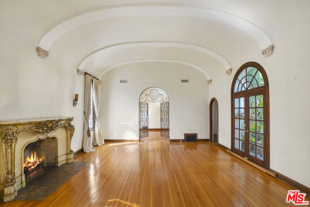 Stunning Spanish Revival home located in the heart of Hancock Park! This one of a kind property features dramatic 15ft vaulted arched ceilings, stained glass windows, intricate moldings and a marble mantle with a gas fireplace, which is decorative. The home features 3 bedrooms and 2 full baths. Set behind wrought- iron gates includes a tranquil courtyard with fountain, an abundant architectural character. A rare opportunity to restore a piece of Hollywood's golden era.