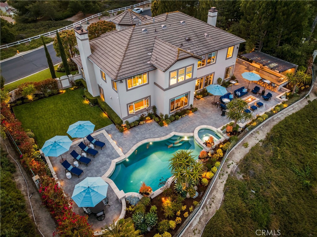 Discover luxury living in the highly-desired Pinnacle neighborhood of Coto de Caza. 32 Panorama showcases unparalleled panoramic views of Saddleback Mountain and the Coto de Caza Valley from almost every room in this beautiful estate. The backyard presents an entertainer's paradise, offering a completely redesigned front and backyard featuring a sparkling pool and spa, outdoor bar with custom cantilevered roof, massive architectural fire pit, surround sound, frameless glass fence for unobstructed views, extensive lighting, large lawn with room for a pickle ball court and stunning views. The completely remodeled interior showcases impeccable design at every turn. With 4 bedrooms including a main level guest suite, dedicated office, craft room (could be converted back to 5th bedroom), bonus room, and 4.5 baths, this spacious home is perfect for families and hosting guests alike. Opening up to the family room, the gourmet kitchen boasts high-end stainless steel Wolf appliances including a 6-burner stove, double oven, microwave + warming drawer, Subzero fridge/freezer, two Subzero wine refrigerators holding 254 bottles, ice maker, and an Asko dishwasher. The Primary Suite delivers a relaxing sanctuary with a fireplace retreat. The spa-like Primary bath showcases a luxurious Calcutta gold marble and crystal fixtures. You'll find a double sink vanity, walk-in shower and soaking tub, plus a large walk-in closet. Additional features include whole-house re-pipe, UV tinted windows, newer dual HVAC system and heating system, Sonos sound system, custom cabinetry, washer/dryer upstairs and downstairs, whole-house water softening system, and so much more! Experience the best of Coto de Caza, where premier living meets award-winning schools, a world-class Golf & Racquet Club, scenic sports parks, and easy access to hiking, biking, and equestrian trails. No Mello roos=low tax rate.