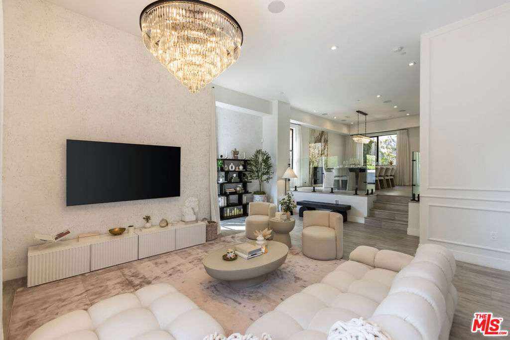 Tucked into the peaceful hills south of Ventura Boulevard, this newly renovated modern home offers an extraordinary blend of style, comfort, and technology. From the moment you enter, you're welcomed by soaring ceilings, abundant natural light, and an open layout that seamlessly connects each living space with effortless flow. Designer touches are found throughout from custom Italian wallpaper accented with 24k gold leaf to refined lime-wash finishes and statement lighting. The chef-inspired kitchen features high-end stainless-steel appliances, a bold center island, and striking Mediterraneo Macchia Antica porcelain surfaces, making it as functional as it is beautiful.The spacious family room, complete with a sleek fireplace, is perfect for cozy nights or entertaining guests. Upstairs, the luxurious primary suite offers a spa-like bathroom with dual vanities, a freestanding soaking tub, walk-in shower, and access to a private balcony with peaceful hillside views. Two additional bedrooms provide ample space, while a separate bonus room/office on the lower level adds flexibility for work or play.A true standout feature is the converted 2-car garage, now a high-performance private gym outfitted with custom flooring, top-tier equipment, and a built-in sauna perfect for fitness enthusiasts or post-workout relaxation.Enjoy complete control and comfort with cutting-edge smart home technology, including Sonos surround sound, NEST thermostat, dual-zone HVAC, tankless water heater, and security-enhancing unbreakable glass.Located just minutes from Westfield Topanga, premium dining, and boutique shopping, this turn-key property offers incredible value in one of Woodland Hills' most sought-after neighborhoods.A rare opportunity at an unbeatable price act fast, this home won't stay on the market for long.