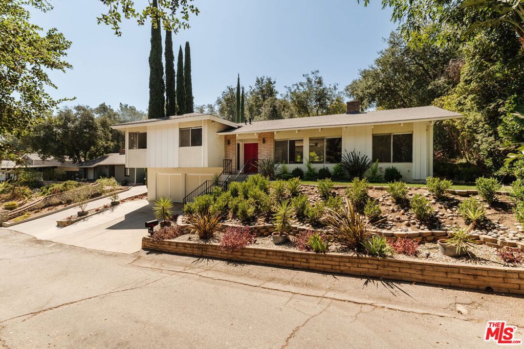 Nestled on a quiet street in the heart of Glendale, directly across from a tranquil wooded area, this beautifully preserved mid-century home offers timeless design and a rare sense of character. With three spacious bedrooms and two full bathrooms, the home captures the essence of classic mid-century architecture clean lines, thoughtful proportions, and a seamless connection to nature. At the heart of the home is a warm and inviting living room, where a striking brick fireplace creates a cozy focal point. Large picture windows bring the outside in, filling the space with natural light and offering calming views of the trees just beyond your doorstep. The adjoining dining area flows into the original kitchen, beautifully maintained and full of vintage charm a true time capsule for mid-century enthusiasts, with classic cabinetry and period details intact. Each of the three bedrooms is generously sized and filled with light, with the primary suite offering its own bathroom and a peaceful view of the surrounding greenery. The private backyard provides versatility and a quiet retreat, perfect for relaxing afternoons or outdoor entertaining under the California sky. With its authentic mid-century details, scenic setting, and an unbeatable location in a desirable Glendale neighborhood, this home is a rare opportunity to own a piece of architectural history where style, warmth, and natural beauty come together effortlessly.