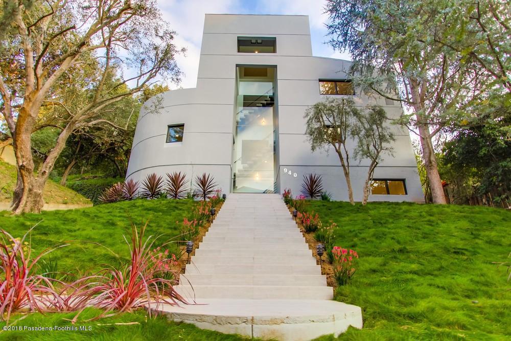 Nestled on a desirable tree-lined street in West Pasadena's San Rafael estate neighborhood by Johnston Lake, this exquisite architect-designed home resembles a piece of contemporary art. Completely remodeled and rebuilt with quality construction & designer amenities in 2017, this stunning home is private, tranquil and takes advantage of the natural topography. The dramatic architecture boasts walls of glass that capture greenery views and allows for the ultimate indoor-outdoor lifestyle. A set of grand exterior stairs ushers guests into a warm and cozy living room. Step up into the spacious dining area that opens to a sleek chef's kitchen with German-built cabinets, stainless steel appliances and Quartz countertops. A glass door opens to a landscaped hillside and carport area. A dramatic floating staircase and a private elevator connect all four levels of this modern home, featuring spacious bedrooms and luxurious bathrooms on each floor. A huge family room with an entertainment balcony, and a lower level media/game room with bar, complete this unique home. Other amenities include central heating and air, tankless water heater, distressed wide-plank floors and Jason Wu designed fixtures. Close to Old Town restaurants and shops, biking and hiking trails, the Rose Bowl, and with easy freeway access to DTLA, studios and the Westside, this is a rare polished jewel in a prestigious neighborhood.